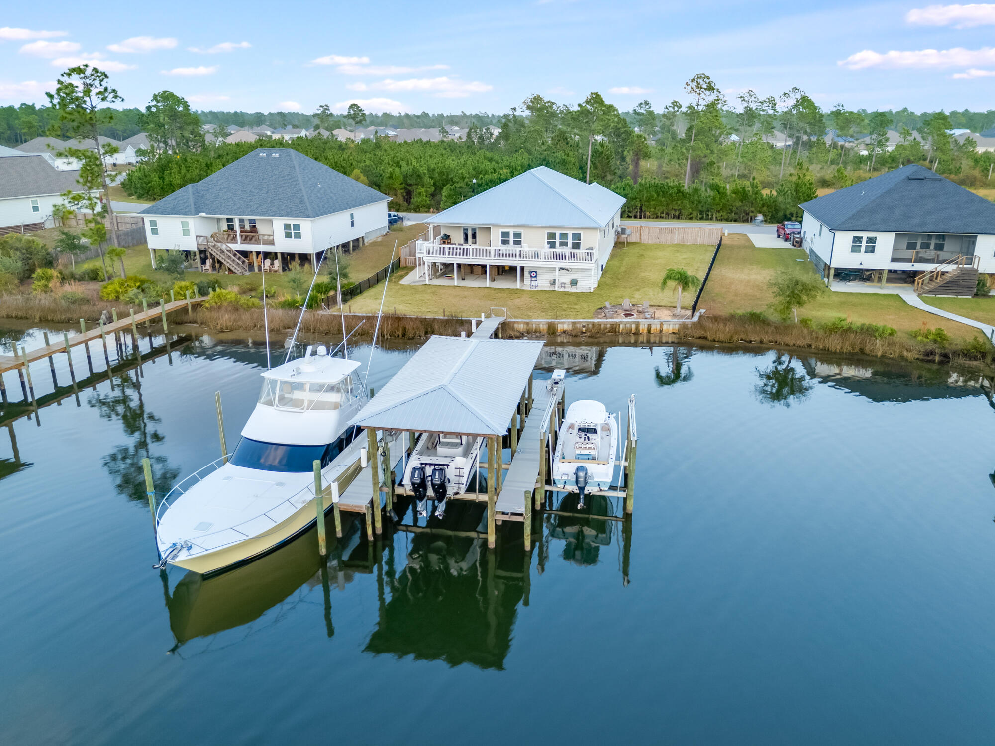 Discover 353 Confidence Way, a stunning waterfront retreat that seamlessly blends elegance with coastal charm along the peaceful shores of Newman Bayou. Offering deep water access, this rare property is a dream come true for boating enthusiasts and anyone seeking the tranquility of waterside living.This beautifully crafted home features a spacious and versatile layout, including four generously sized bedrooms, a private study, and a two-car garage with an additional bay for a third vehicle or golf cart. The expansive covered deck invites you to enjoy outdoor dining and relaxation, with direct access to your private dock for endless aquatic adventures. Inside, the elegant foyer leads to two bedrooms sharing a thoughtfully designed bathroom with a double vanity and a shower-tub combination. Trey ceilings add a sophisticated touch to the dining room, living room, study, and luxurious primary suite.The gourmet kitchen is a chef's delight, featuring a central island with a sink, ample cabinetry, a corner pantry, and premium appliances. Adjacent to the kitchen, you'll find a cozy breakfast nook. The primary suite offers a private retreat, with a spa-inspired bathroom showcasing a garden tub, a separate shower, and an expansive walk-in closet.

Experience the perfect blend of tranquility and luxury in this extraordinary waterfront home. Don't miss this opportunity to experience the pinnacle of waterfront living. 