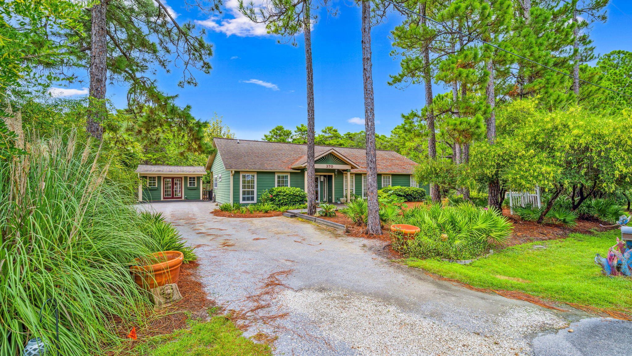 One mile from the beach, this three-bedroom, two-bath retreat rises 30+ feet above sea level on a rare oversized lot, an elevated vantage point that few properties in the area can claim. Behind the home, protected state forest land stretches endlessly, ensuring permanent privacy, quiet mornings, and unspoiled views.No HOA means no limits. Add a pool, expand your living space, or craft a backyard escape that's all your own. Two matching outbuildings extend your possibilities, one fully insulated with heating and cooling, ready to serve as an art studio, workshop, or home office. This is more than a home. It's a blank canvas of coastal living with nature at your back door and the Gulf just steps away. Enjoy the convenience of having Gulf Place Town Center, and restaurants such as Shunk Gully, Shelby's, shopping, and more just 1 mile away. Contact us today for a private showing.