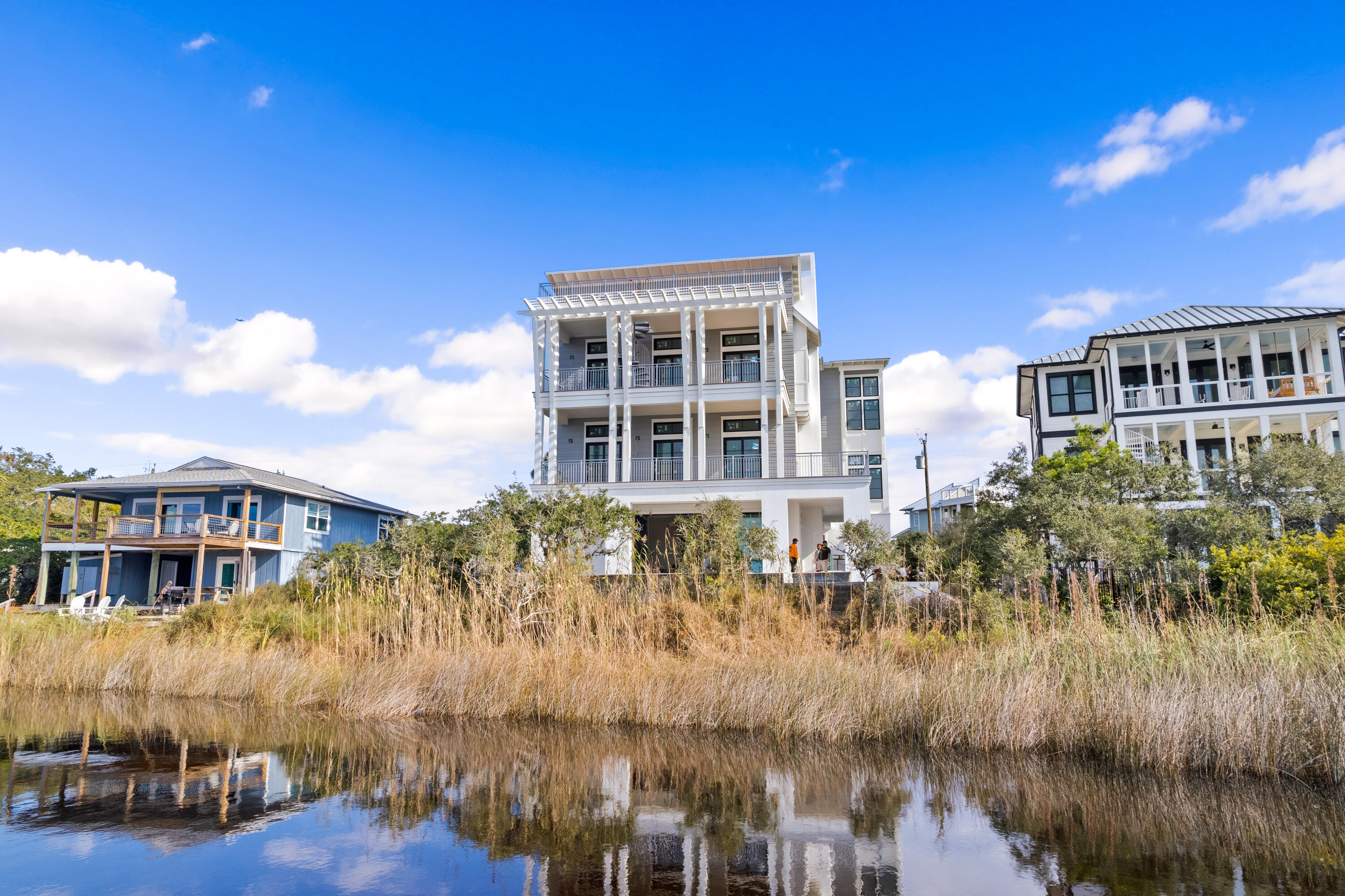 Perfectly positioned in Seagrove Beach along 30A, this compelling new construction opportunity sprawls along 75' of Eastern Lake frontage framed by the picturesque landscape and idyllic Gulf views. Designed by the acclaimed team at Geoff Chick & Associates, the floorplan encompasses over 5,600 square feet of expertly planned living space spanning three levels interconnected by both stairs and an elevator.The cantilever roofing, expansive window walls, and articulation of exterior lines expose an especial modern flair while holding true to the coastal design. Upon entering the first floor you are greeted by a living area with summer kitchen and direct access to the outdoor oasis with oversized pool, hot tub, and private dock.