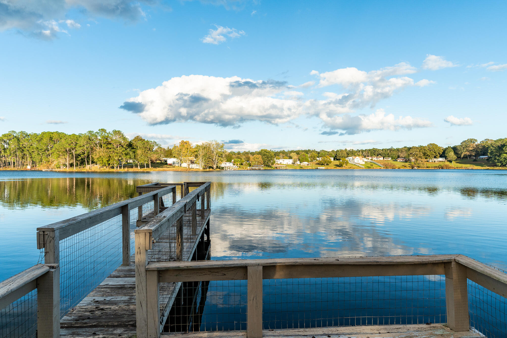 Waterfront Home with over 135 feet on King's Lake. Enjoy the wonders of island living in this well-maintained three-bedroom, two-bath home. Fish off the dock or launch your boat from ramp in your yard. The lake is teaming with fish so that the avid angler can enjoy endless fishing days. Newer metal roof (8 years old) and HVAC system with new air ducts. Storm windows in place for the entire house and hurricane shutters when needed. Covered front porch. Fully fenced yard. Bulkhead around water's edge. With a 32' fishing pier and a 14' wide boat ramp with a covered boat dock. Located on quiet, paved, dead-end road. There is a lovely assortment of fruit trees, peaches, fig, lime, oranges and a blueberry bush.