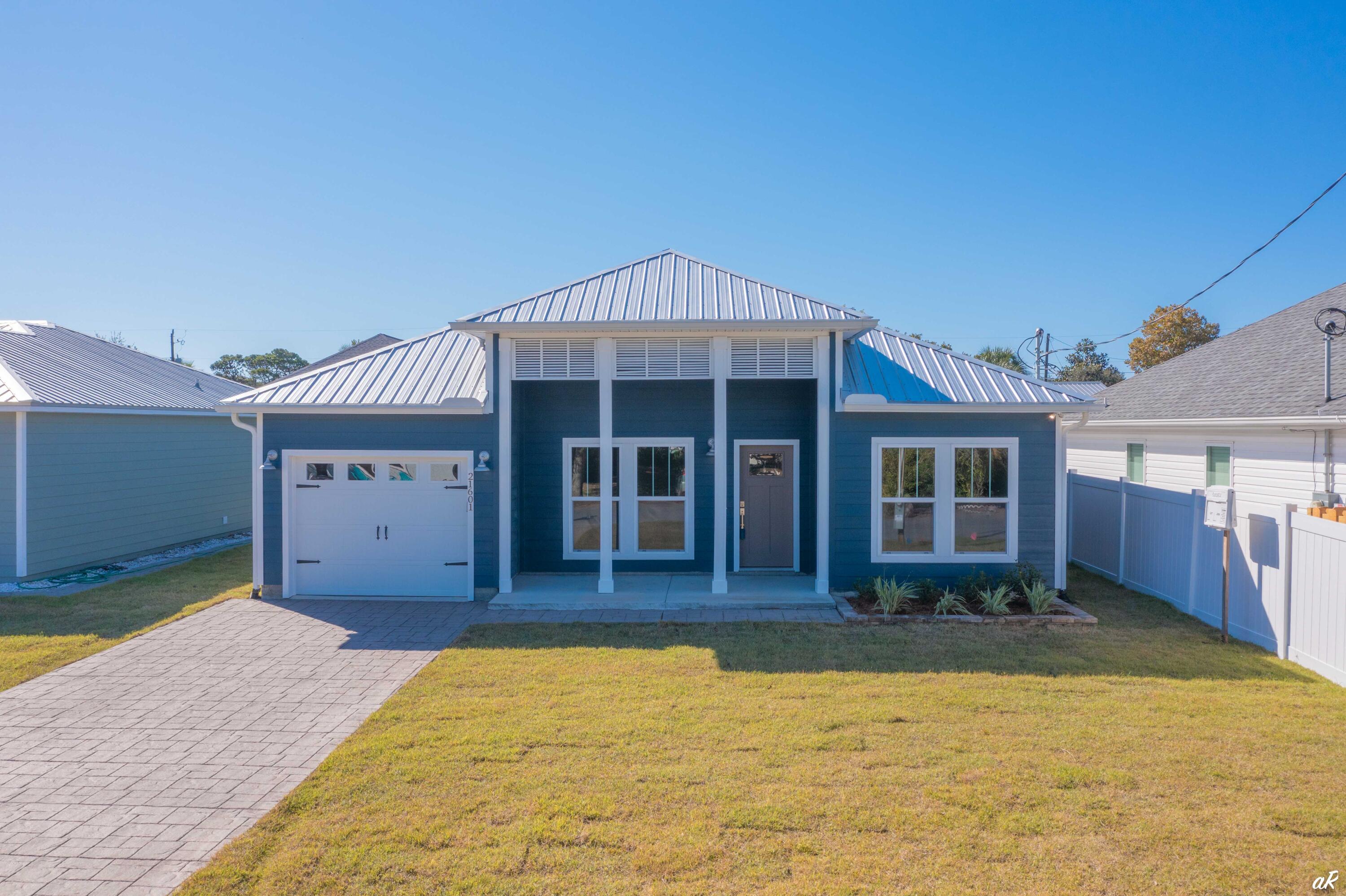 3 bed, 2 bath BRAND NEW CONSTRUCTION home on the West end of Panama City Beach! Less than half a mile to the white sandy beaches and short-term rentals are allowed! Every detail was thought of when building this home. This home features a stamped concrete driveway and covered front porch with columns and modern light fixtures. The living room, dining area, and kitchen feature an open floor plan that is perfect for hosting family and friends. The living room and kitchen feature shiplap walls. The kitchen boasts stainless appliances, quarts counters, a kitchen island with a sink, a dishwasher and a breakfast bar, white shaker cabinets with soft close features, tile backsplash, recessed lighting, and a barn door. The dining area boasts a beautiful, modern chandelier. The spacious primary