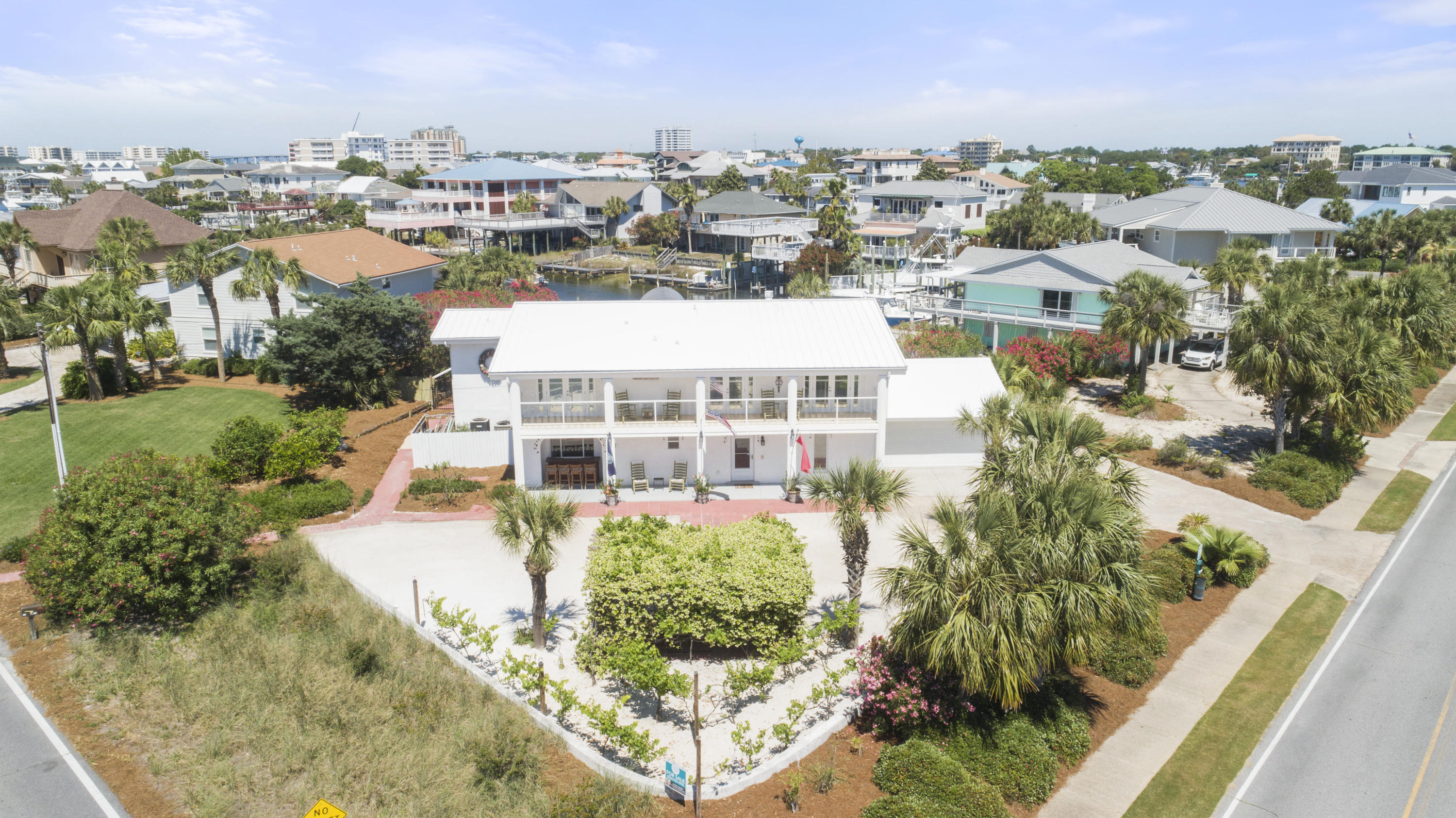 There is not another property to compare this to. From the moment you arrive you will be absolutely captivated. This home is quintessential Holiday Isle living with a Mediterranean flair. A productive vineyard in the front of the home currently enables the future homeowner to make fantastic Malbec and Sangiovese wines. Private Gulf access beaches just steps away from the front door, dual boat slips  one with a lift, gorgeous brand-new saltwater pool, and a back patio that makes your entertaining dreams come true are a few of the features making this house your home. When you enter the front door, you're met with soaring ceilings, new flooring, exquisite Schonbek chandeliers, two story fireplace, as well as a view to the canal through 8 amazing picture windows.
