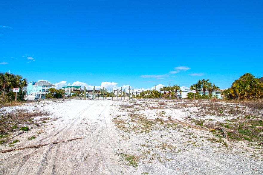 One of the only lots available on Holiday Isle. Walk to the beach from this Large corner lot located on a deep water canal with 2 boat slips. This lot is very high and dry. The owner retained all of his fill when dredging the canal and the property is high in elevation. A Perfect Place to build your Dream Home. Come and take a look. See You at The Beach!