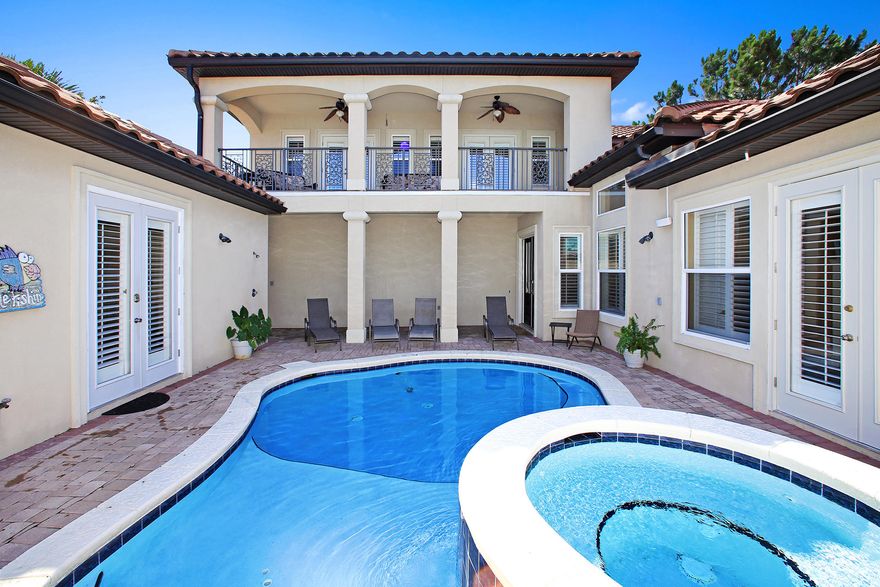 Custom Mediterranean Villa in Gated Destiny East with Courtyard Pool, Guesthouse, and First-Floor Master Suite. $70K/year is vacation rental income managed by owner. Just past the home's private iron gate, a stunning courtyard pool introduces the home and guesthouse. At the center of the home, the courtyard provides exceptional privacy and visual comfort. The luxurious, freeform pool features an elevated spa and tanning ledge for the ultimate in enjoyment. As you enter the main house, an inviting open-concept floor plan greets you. Travertine floors, built-in cabinetry, and tray ceilings add visual interest. The gourmet kitchen boasts granite counters, a custom tile backsplash, Monogram stainless appliances, large breakfast bar, and an island with a wine refrigerator and vegetable sink. Designed for entertaining, the dining room can accommodate a large table with seating for 10. The first-floor master suite provides immediate access to the pool. The luxurious master bath features spa amenities including separate vanities, a spa tub with stone inlay, and large walk-in shower with multiple showerheads and body sprays. Bose surround sound provides entertainment on the first floor and the pool area. An office, laundry, and powder room complete the first floor. On the second floor, there are three guest bedrooms, one with a private bath and the others with a jack-and-jill bath. Two of the bedrooms offer access to the second floor balcony overlooking the courtyard and pool. The bunk beds in one bedroom assure kids have their fun space to sleep. The separate guesthouse with a bedroom and full bath provide extra privacy for guests. This home would make a great full time residence or rental property. The beautiful waters of the Emerald Coast are just a short golf cart ride away. Gated Destiny East boasts many amenities including a large clubhouse with a gym and theater, 2 lighted tennis courts, basketball court, a large pool and hot tub, playground and grilling areas. The neighborhood is centrally located near restaurants, golf courses and shopping, many within a golf cart or moped ride. Don't miss this opportunity to buy one of the lowest priced per square foot homes in Destiny East.  