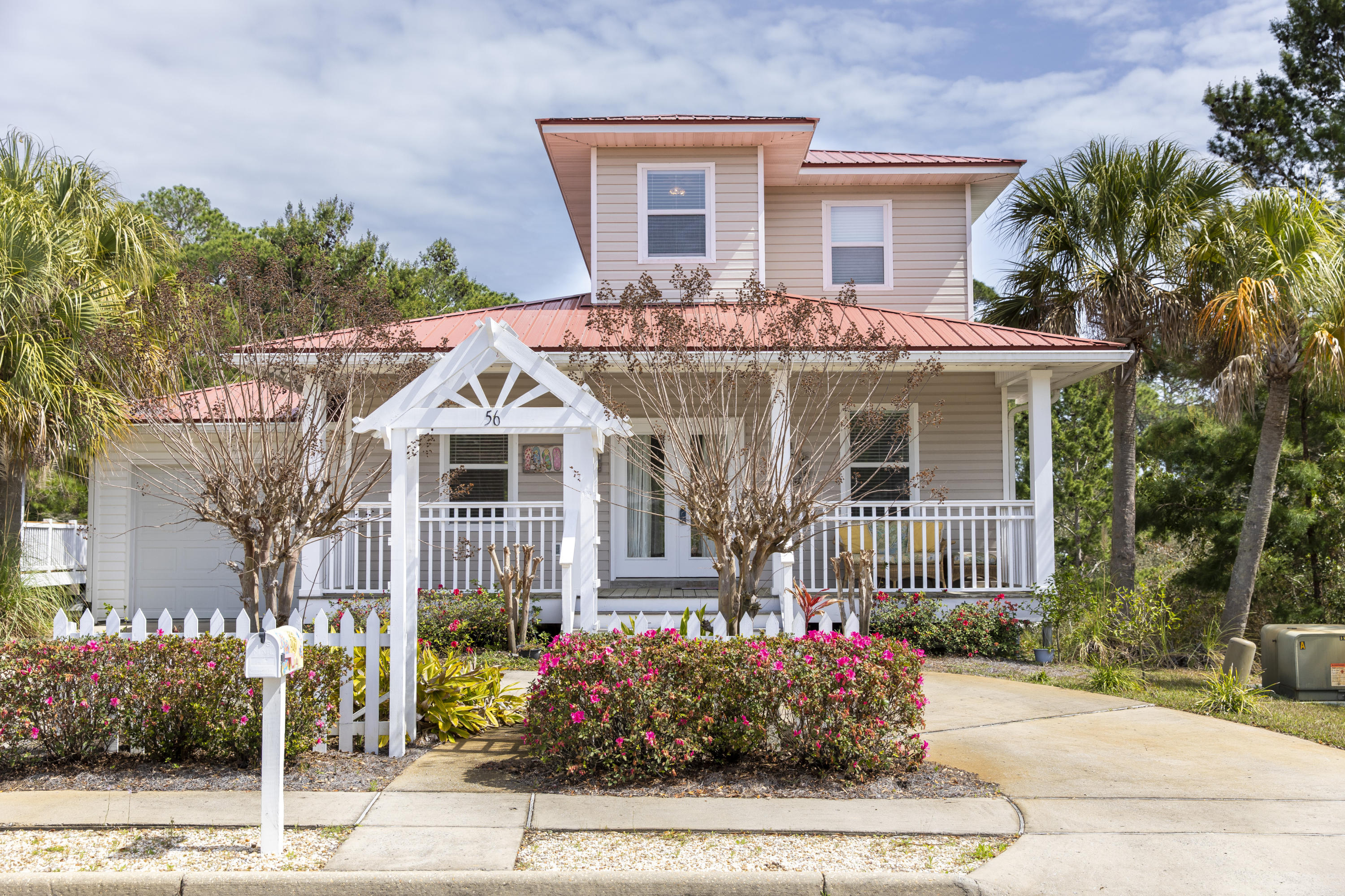 Absolutely perfect Florida Beach Cottage located in the low density Sea Dunes subdivision. This home is surrounded by a white picket fence, wrap around porch, and private wooded backyard. Turn-key, and fully furnished, 56 Tradewinds offers the perfect setting for beach-goers and family alike. The floor plan of this home was designed with family and entertaining in mind with open floor plan on the first floor with kitchen facing out to the living room. The kitchen is a chef's dream with granite countertops and tile flooring. The downstairs is a walkout level with a very large separate living area, and two private bedrooms with a full bath. The upstairs is a master bedroom suite with a small landing area for a reading nook or office area.