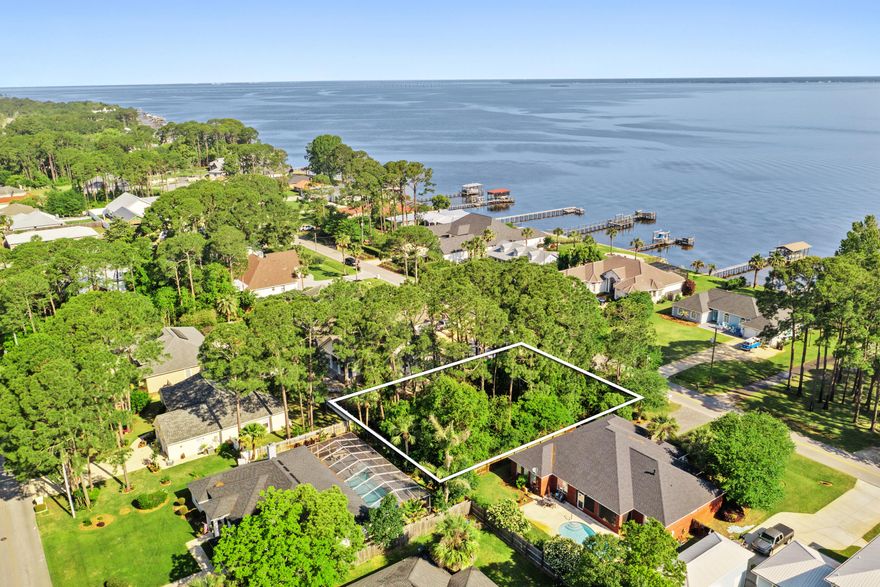 Under contract. Taking backup offers during due diligence period.Rare find! Buildable lot across the street from the bay. Breathtaking water views and sunrise views from second story with the right floor plan. A couple block walk to the bay/park. Boat ramp just down the road. 6 Minute drive from public beach access in Miramar Beach. Quiet neighborhood! Survey available. Will need to pay to tap into city water, etc. Build your dream residence or build for a rental. Buyer to due all due diligence.
