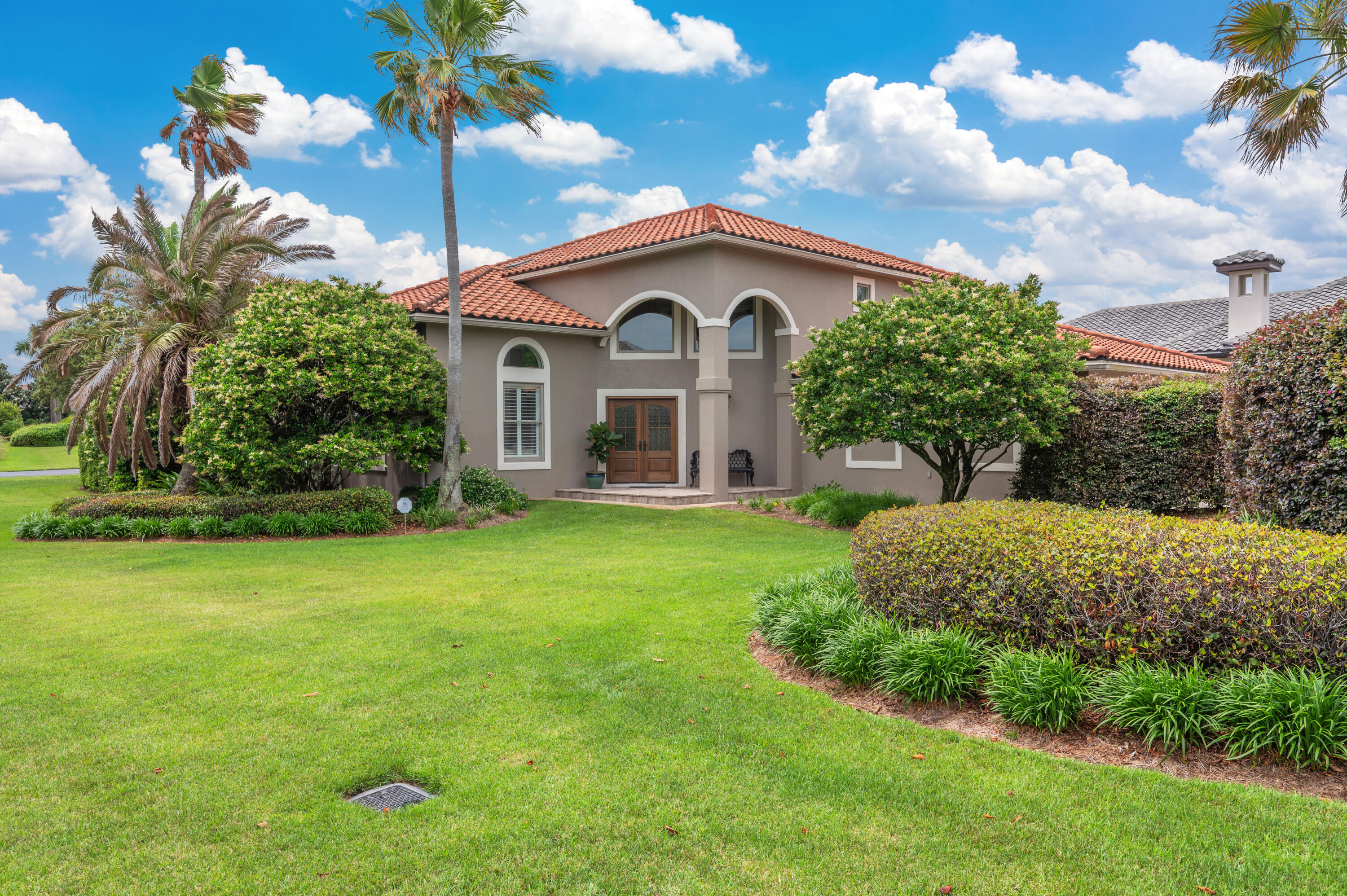 Situated on a beautifully landscaped 0.35 acre corner lot in the exclusive, gated community of Bellamar at Gulf Place, this Mediterranean-style residence offers 4 bedrooms, 3.5 baths, and 3,347 square feet of refined coastal living. Just steps away from a private neighborhood path leading to Gulf Place and a deeded beach access, this home combines privacy, space, and a premier 30A location all at the most attractive price in the community. With solid construction and generous square footage, it offers the chance to personalize and enhance the home to match your vision and lifestyle. The main level features one of two spacious primary suites, complete with a fireplace and en suite bath. Newly upgraded flooring flows throughout the first floor, where two expansive living areas with 17-foot ceilings and an abundance of natural light create a sense of openness and elegance. One living area, featuring its own fireplace, seamlessly connects to the kitchen, complete with an island and serene backyard views. Adjacent to the kitchen is an office space, perfect for a home workspace or a quiet place to unwind. The other living area opens to a formal dining room, providing an ideal setting for entertaining.
The second level includes a second primary suite, two additional guest bedrooms, and a full bath. The upstairs layout is ideal for guests offering a private, tranquil retreat away from the main living spaces.
The fenced backyard is framed by mature palms and designed for year-round enjoyment with a heated pool, screened-in porch, and fire pit. With timeless architecture, flexible living spaces, and direct access to the best of 30A, this is an exceptional opportunity in one of the area's most desirable locations.