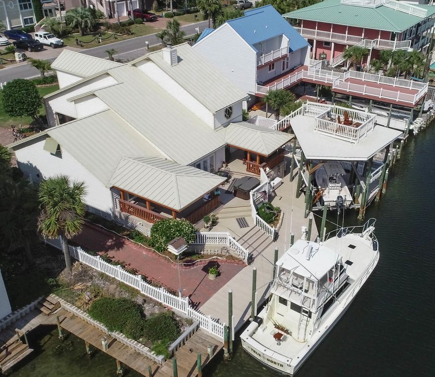 Beach & Boater's Paradise-'TWO STORY HOUSE: 4bedroom - 3 1/2 bath - 3,200 Sq Ft THE HOUSE: Located on a deep water canal on Holiday Isle, Destin, FL this offering is the ultimate for instant paradise... beach house, boat, and bar! Located on the east residential section (no condos) of Holiday Isle one block from the gated access to the white sand beaches of Destin. Deep water canal leads to the Destin Harbor, the Destin Inlet, and the emerald coast's fishing and boating waters. It's a short drive to Hwy 98 and hundreds of shops and restaurants. Dock remodeling in 2015 included: new vinyl bulkhead/seawall, new pylons, and new composite material decking. House remodeling in 2015/2016 included standing seam metal roof, office room over garage, 500# cargo lift from garage floor to office room,