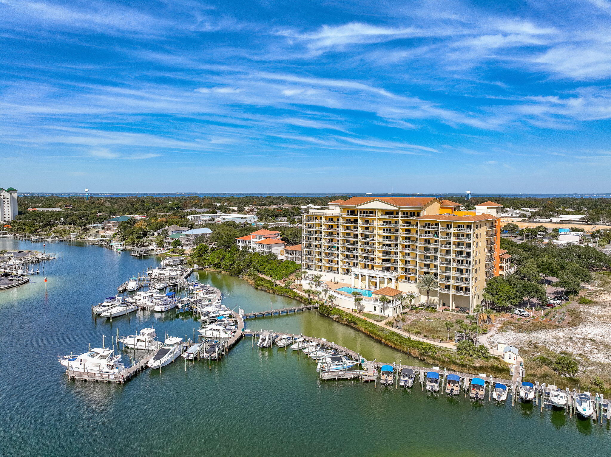 Enjoy stunning bluff-top views from this stylish 2 bedroom, 2 bath waterfront residential condo! The open floor plan features 9 ft. ceilings, rich Tigerwood flooring,and upgraded appliances. The comfortable primary suite includes double vanities, a soaking tub, and separate shower, as well as ample storage. The second bedroom provides an inviting retreat for guests. Additional features include plantation shutters, a large private storage unit, and 2 assigned covered parking spaces. Relax on the private balcony with morning coffee or watch sunsets over the water. Marbella has a fitness room, a community room, a heated pool, and hot tub. The building is located conveniently to the Harbor District and is home to the Marbella Yacht Club. Boat slips can be purchased. No short term rentals.