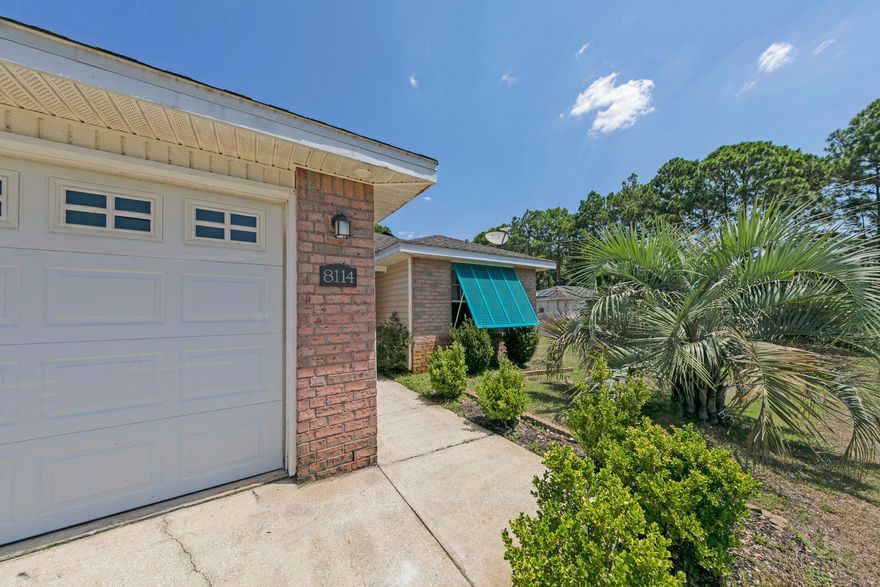 NEW ROOF to be put on before closing! Time to own your own piece of paradise! This 3 bed, 2 bath Navarre home has been lovingly landscaped and updated to become a beachy-vibe getaway that you can enjoy year-round. Palm trees welcome you by the driveway and the Bahama shutters add a flare of color to the brick and vinyl exterior. Through the front door you'll find a welcoming floorplan with new LVP flooring throughout the common areas and master bedroom. A hallway separates the guest rooms and guest bath from the rest of the home on the right. Further past the living room is your dining area overlooked by an updated kitchen with breakfast bar. Kitchen has quartz countertops, modern white cabinetry and stainless steel appliances. There is also a dedicated pantry and coffee bar with a driftwood-stained, butcher block countertop and mini-fridge. Between the kitchen and garage-entry door is your laundry room with washer and dryer situated on either side for ease of transferring your loads from one machine to the other. Just off the living room to the back of the home is your primary room that is filled with natural light! Dual sink vanity and walk in closet located in the en-suite bath. Outside you'll find your private oasis! Palm trees frame your stone stacked firepit, perfect for gatherings and cooking up some s'mores or enjoying a beverage with friends. Your nearly half-acre lot is privacy fenced in the backyard and give you the feel of seclusion while only minutes from Publix, several dining options and Navarre's gorgeous white-sand beaches! Low or no energy bill provided by solar panels which will be paid-off at closing. You are a phone call away from living the Florida lifestyle. Call today to schedule your tour. Please be mindful that audio and visual recording is in use on premises.