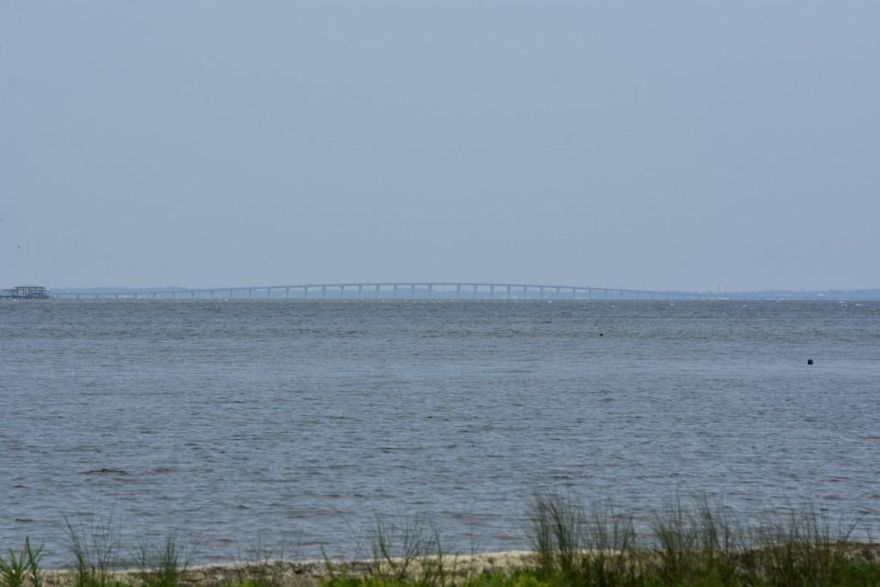 What a spectacular view! This one-half acre of land is a great place to build your dream home. You can see the Bayou, Bay, and Mid Bay Bridge from this property. There is approximately 241 ft of frontage on the Bay, all with a concrete seawall, plus a dock. The property includes a 2 bedroom home that needs work, and a shed. It has been given no value and is included ''AS IS''. Please verify any info of importance to you, including school information, zoning and utilities. Be sure to look at the pictures and documents. Also listed as Residential, MLS# 734102. Take a look today!!!