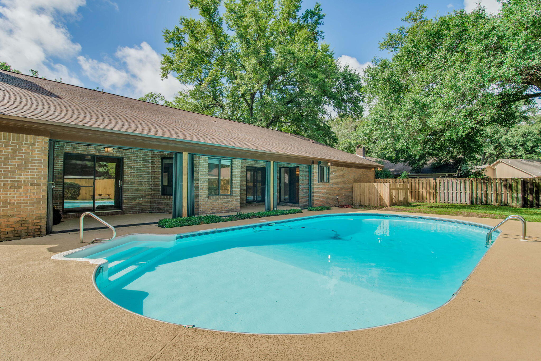 POOL HOME in North Pensacola -No HOA! This beautiful spacious home features an updated kitchen, nestled in a serene neighborhood with mature trees & foliage. Conveniently located near the mall, airport, shopping centers, hospitals, and schools.Throughout the home you will find solid surface flooring. The spacious master suite features two walk-in closets & a large bathroom with a  whirlpool tub, separate shower, and private access to the pool area. There are 2 additional bedrooms, a second full bathroom, an office, & large laundry area leading into the side entry garage. There is also a dedicated dining area, Living room & a family room complete with a fireplace & fully renovated kitchen!  Both living areas lead to an outdoor oasis a sparkling pool, and a covered patio for entertaining.