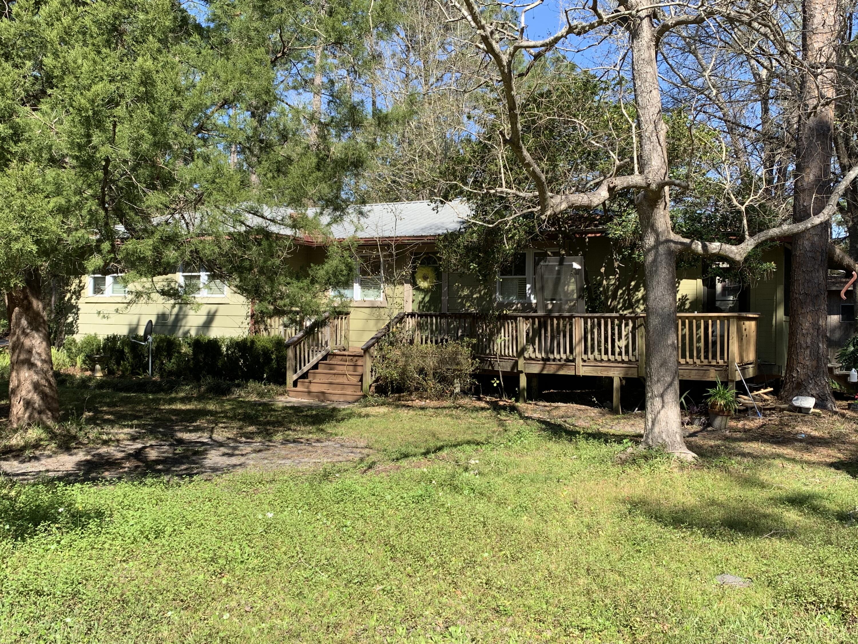 Great location walking distance to boat ramp at Cessna Park. No HOA!!! This property includes the home on one lot with 3 additional lots for a great estate or investment. On public water and sewer with additional well for Irrigation. Beautiful mature landscaping property has a gas stove with private above ground propane tank. Newer dishwasher and refrigerator, recently serviced air conditioning unit seven years old, real pine living room floors and bamboo in bedrooms. Several outbuildings for storage and workshop space. Don't miss out on this great opportunity.