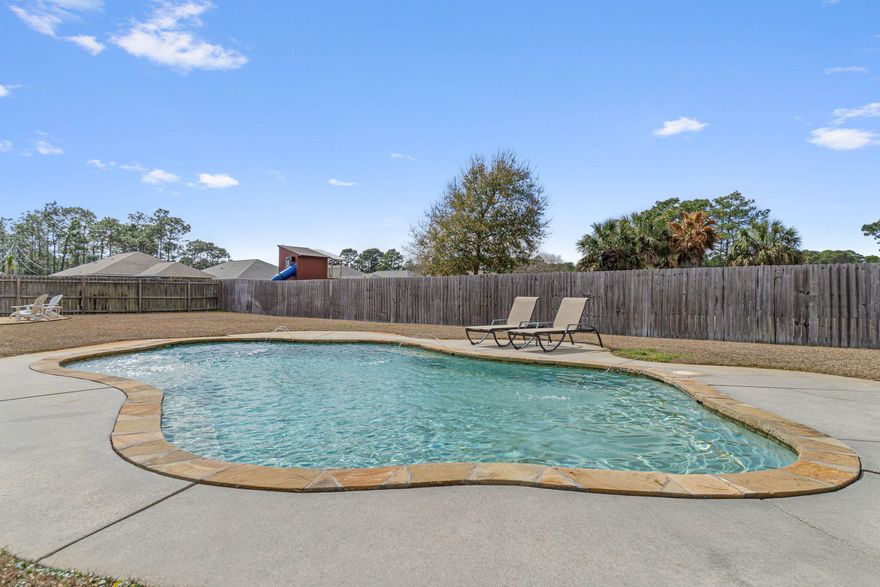 Welcome to 8155 Sierra St, Navarre, FL--a beautifully maintained 4-bedroom, 2-bathroom home offering 1,845 sqft of modern living space. Built in 2015, this home combines contemporary comfort with energy efficiency, thanks to paid-off solar panels that help lower your energy costs! Located just 15 minutes from Navarre Beach and 25 minutes from Hurlburt Field, this home is in a prime location.Step inside to find an open-concept layout with a spacious living area, perfect for entertaining. The kitchen features sleek countertops, modern appliances, and ample cabinet space. The primary suite is a private retreat with an en-suite bathroom, while three additional bedrooms provide plenty of room for family or guests.