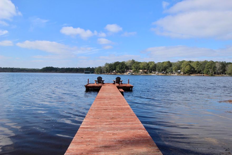 Picture perfect waterfront getaway on award winning bass fishing lake, Lake Juniper. Meticulously updated & maintained, this place is sure to feel like home - or maybe a second home! Stunning views from the kitchen, breakfast area & living room. The screened back porch is both comfy & cozy - with corrugated metal walls & roof for a farmhouse style setting. Clever sliding barn door reveals built in storage off the porch. All updates within the last 5 years including metal roof, wood skirting, sod, irrigation, fencing, seawall & dock, new flooring & paint. You'll also find new appliances in your stylishly updated kitchen. Being sold partially furnished, so moving in will be a breeze. Qualifies for all types of financing, including FHA & VA. Fish, kayak, or simply...sit. Relax. You're home...