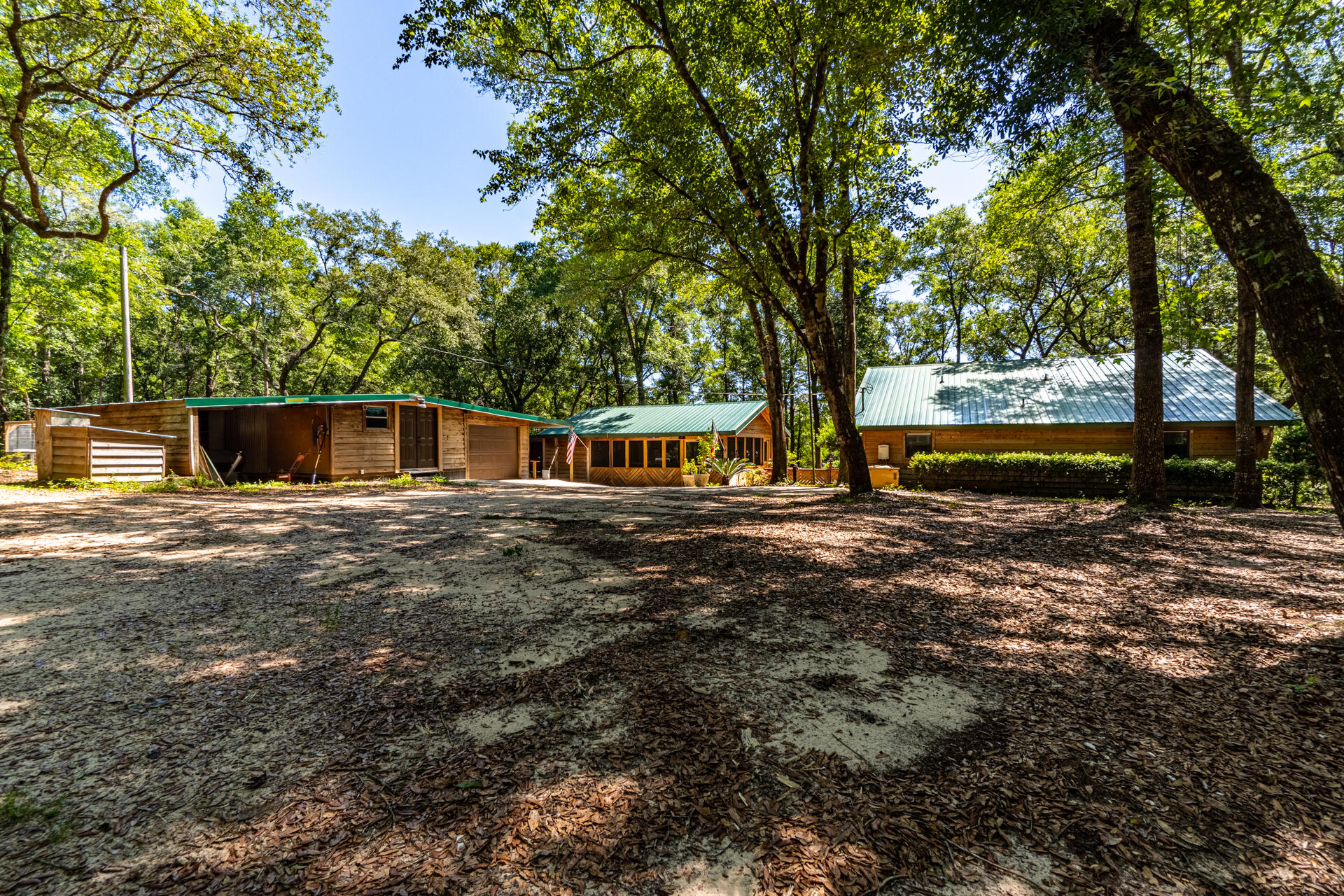 Four Buildings and all have Metal Roofs!!! OPEN YOUR EYES TO PARADISE SURROUNDED ONLY BY NATURE!!! A HIGHLY MOTIVATED SELLER NEEDS TO SELL!!! He needs more acreage, so help him move!! This home is Hand-Built with Juniper wood in the middle of Three Acres. Juniper wood has excellent resistance to termite and fungal attacks.      This Unique home comes with ALL Appliances ( Three refrigerators, dishwasher, stove, washer, and dryer ) and a Reverse Osmosis Water System, New Carpet, New Floor planks, and Open concept, and Updated Bathroom. Off the living room- Covered and Screened Patio Deck with outlets, lights, a Jet Jacuzzi, Privacy, Pond views, deer views, Nature views, and cable. AND