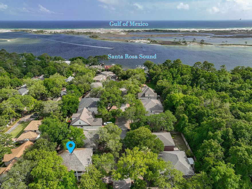 Gorgeous home in the waterfront community, Plantation Oaks, in Mary Esther, FL with 4 bedrooms and 3.5 baths and 3398 sq ft! This waterfront community is located only minutes to the white sandy beaches, excellent schools, local restaurants, the military bases. This 2 story home has wrap around porches (984 sq ft), stucco columns, brick veneer and beautiful mature landscaping! Nestled in the corner of this desirable neighborhood, the exterior of this home  is like a New Orleans court yard. The driveway is completely paved and there is a walkway leading to the covered front porch. There is  ample parking for 4-5 vehicles, a 2 car garage, fenced in back yard, windows with transoms and wood shutters, exterior crown molding, and custom 8 foot front doors with large sidelights. Enter this home in a wide foyer with double height ceilings and on either side of the foyer you will find the dining room and a home office. Ceiling medallions, chandeliers, triple crown, and 6 inch base boards are just a few of the interior design features. Each room has grand archways leading to the foyer and kitchen! The kitchen has a view of the back yard and features a side by side stainless refrigerator with icemaker, slide in electric cook top stove/oven, a beverage or wine refrigerator, built in microwave and dishwasher, level 3 granite countertops and back splash, under mount sink, custom wood cabinetry with a built in wine rack, chandeliers, pendant and recessed lighting! The peninsula is perfect for entertaining and seats 4-5 (approximately 9 feet). Double doors lead to a large pantry with shelves. Enter the large living room and notice the new electric fireplace, triple windows with transoms overlooking the fenced back yard and patio. The door leading to the open patio has built in blinds. The flooring throughout the downstairs is hand scraped wood laminate and tile. The walls have been painted a modern grey with white molding and ceilings. Some ceilings have been painted custom colors to add richness to the space. The living room also features custom sconces and ceiling fans. There is a half bath downstairs and the bathroom features a furniture vanity with custom mirror, lighting, and granite countertops.  The custom oak staircase features a custom staircase runner and black aluminum railing.  carpet leads to a large landing and 4 bedrooms and three full bathrooms. The primary bedroom features a large walk in closet with shelving and double doors to a grand primary bathroom. This bathroom has a spa tub, walk in shower with rain head shower faucet, two sperate vanities, and a make up counter. The tub and walk around shower are cultured marble with a large frameless glass separating them.  The primary bathroom features a chandelier, sconces, and recessed lighting. In addition, natural light abounds in this space with the two large block glass windows. Upstairs there are an additional two bedrooms that share a Jack and Jill bathroom and the fourth bedroom has an ensuite bathroom. The laundry room is upstairs and is adjacent to three of the bedrooms. The exterior door upstairs leads to a large wrap around covered porch (76 linear feet) with custom metal railing. Relax on the upper or lower covered porch and enjoy the beautiful mature vegetation (Oaks and Magnolia Trees) and landscaping in this yard. The backyard has a large pergola covering a large paved patio area (28x13 ft) with a built in bar top. There are two HVAC units for this home, one was replaced in 2023 and the second was replaced in 2019. The home features a tankless hot water heater. This waterfront community is located only minutes to the white sandy beaches, excellent schools, local restaurants, the military bases. Buyer to verify all dimensions and information. 