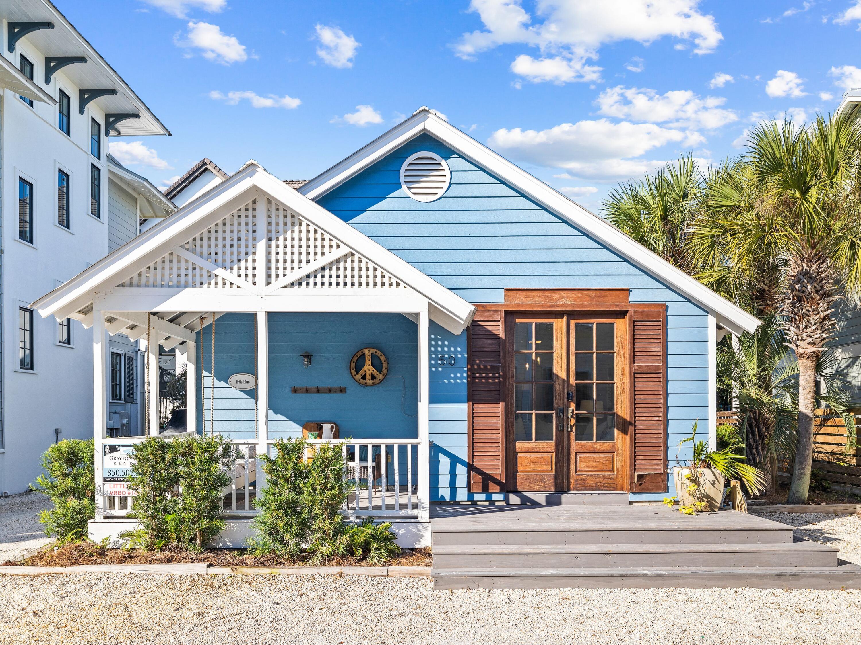 UNDER CONTRACT, ACCEPTING BACK UP OFFERS. Welcome to ''Little Blue'' on famous Grayton Beach! Filled with charm, this characterful beach cottage is nicely updated and comes with its own private yard oasis. Beach fans, and savvy investors, will love the LOCATION just one back from the white sand and emerald waters of Grayton Beach. Laid out on one level, the cottage is surrounded by shady palms and has its own private parking pads at the front and side. Steps lead up to the front porch which tempts you to pause awhile and enjoy the alluring gulf and lake views from the cushioned swing seat. Double doors with shutters lead inside to the open sitting room with hardwood flooring. The soaring vaulted ceiling adds light and space to the laid-back ambience with shafts of sunlight pouring in