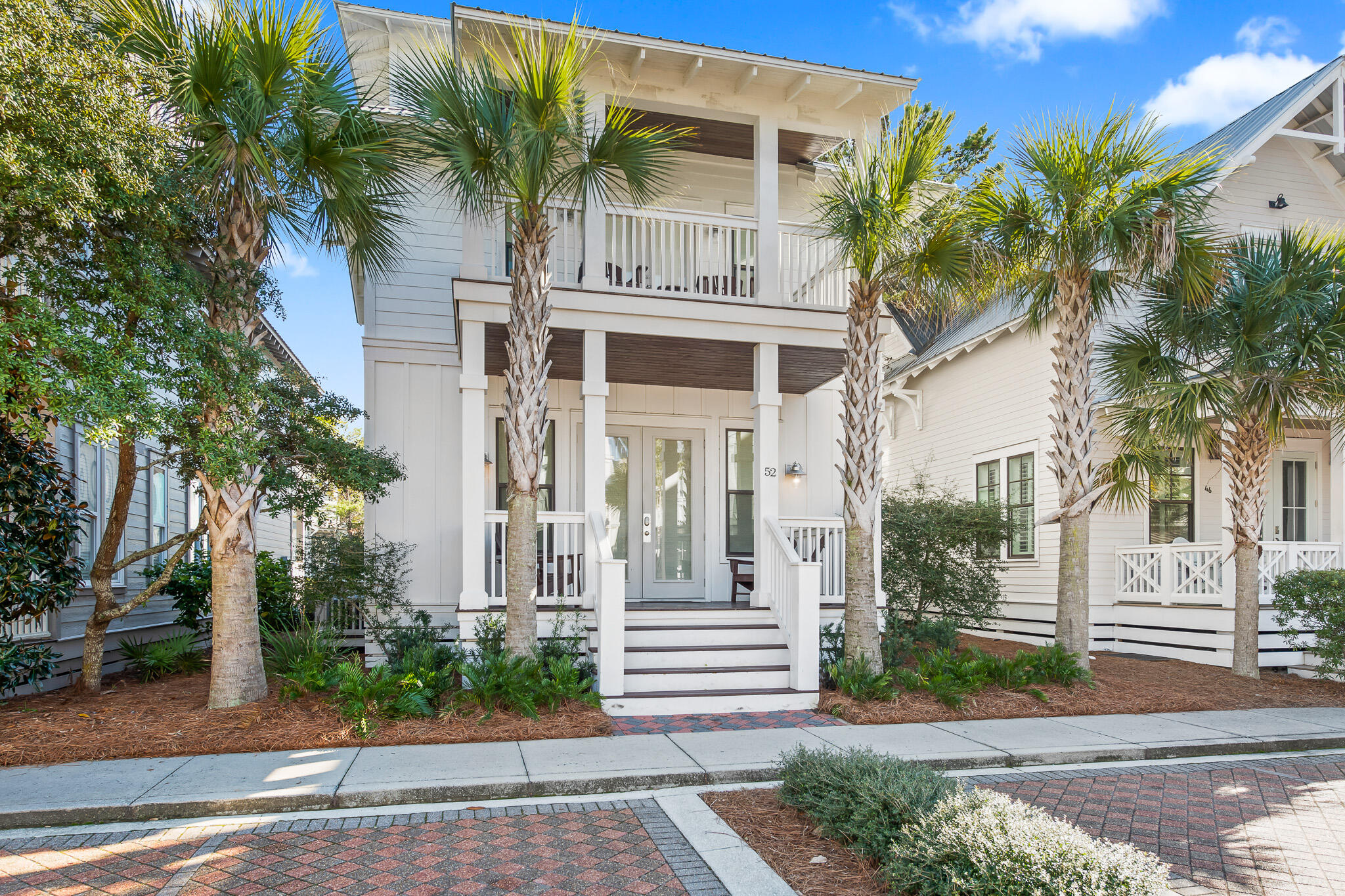 Sophisticated decor and a thoughtful floor plan, combined with a stellar location within Seacrest Beach, make 52 East Seacrest Beach Boulevard the ideal beach home. Spacious porches and balconies on every level create beautiful curb appeal, and the interiors are comfortable and inviting. The entrance to the legendary Seacrest Beach lagoon pool is less than fifty feet from the front door, or catch the tram to the beach at the pick-up one door down.Once you're inside the home, you'll find an inviting ground floor with a large, open floor plan, including a chef's kitchen with a large island, farmhouse sink, ample bright quartz countertops, and ceiling-height cabinetry. The dining table seats eight, with room for four more at the bar, or relax on the comfortable sofas and chairs in the