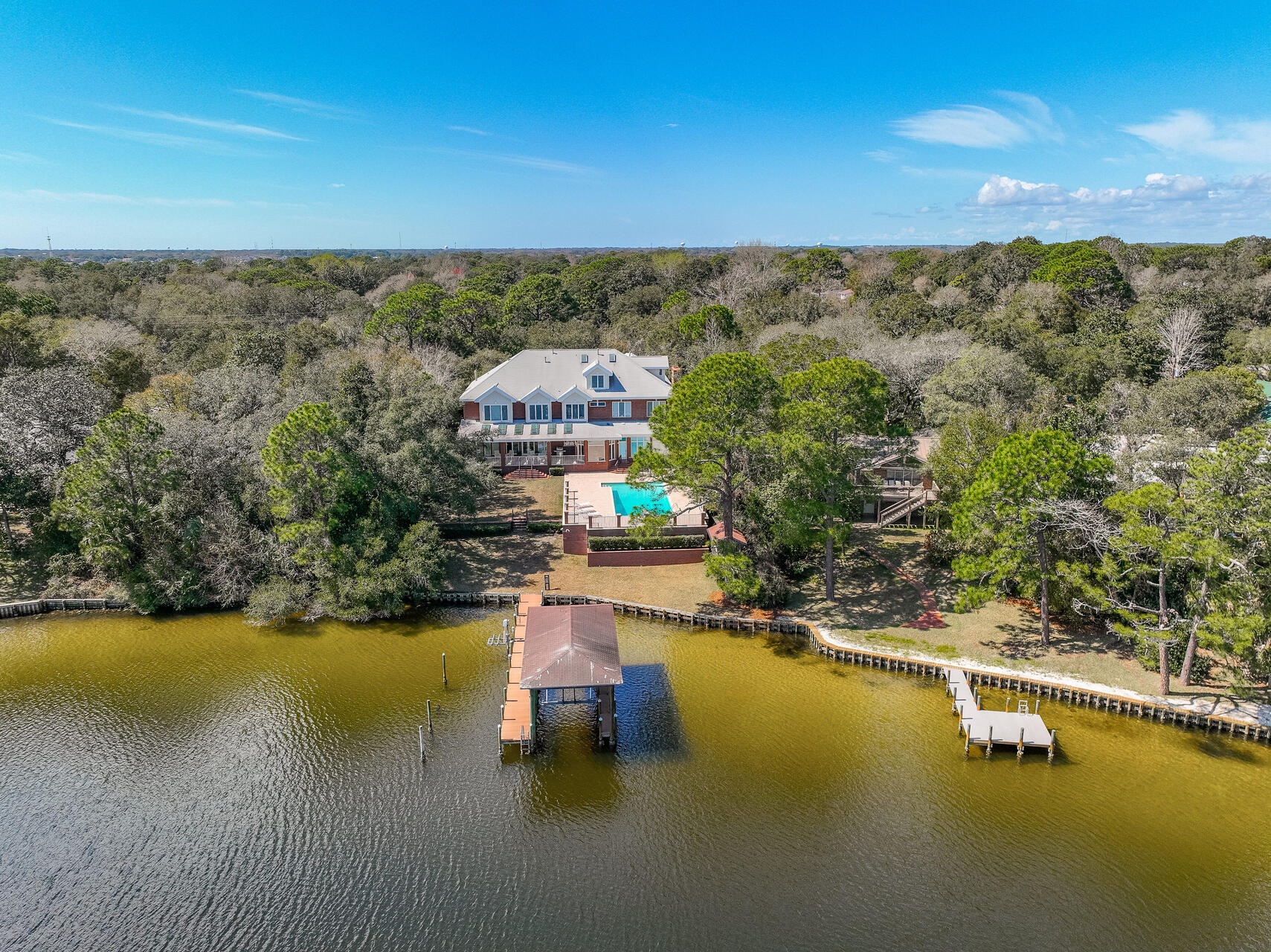 With over 100 feet of frontage on Poquito Bayou and deep water access, this traditional brick southern home desires a large family that loves the water and boating!  Gorgeous property with private driveway and set on high elevation; this 9,000 plus square foot home with an oversized 4 car garage offers lots of space for a growing family with 6 bedrooms, and 7 full baths! The pristine swimming pool was re-plastered and the surrounding patio had new deck pavers installed in 2018 creating the perfect setting for an afternoon of relaxation or a celebration with family and friends.  An enthusiastic chef will enjoy cooking in the gourmet kitchen with wood mode cherry cabinets, a Viking gas stove, Sub Zero Refrigerator and Freezer, and solid granite counter tops. Marble floors flow through the kitchen and front entry way and hardwood floors course through the library, living and dining room.  The beautiful library invites the avid reader to find refuge with solid cherry wood built-in bookcases that span the length of several walls.  A large laundry room and an ample pantry plus big bathrooms make everyday life pleasant. Transoms above the windows and doors bring in the natural sunlight and create a cheerful interior. With 10 foot ceilings on the first and second floor this home exudes comfort with grandeur and stunning water views from most rooms in the house offer solace and calm.  Poquito Bayou opens to the bay which has access to the Gulf of Mexico via Destin Harbor or Pensacola Pass. 
