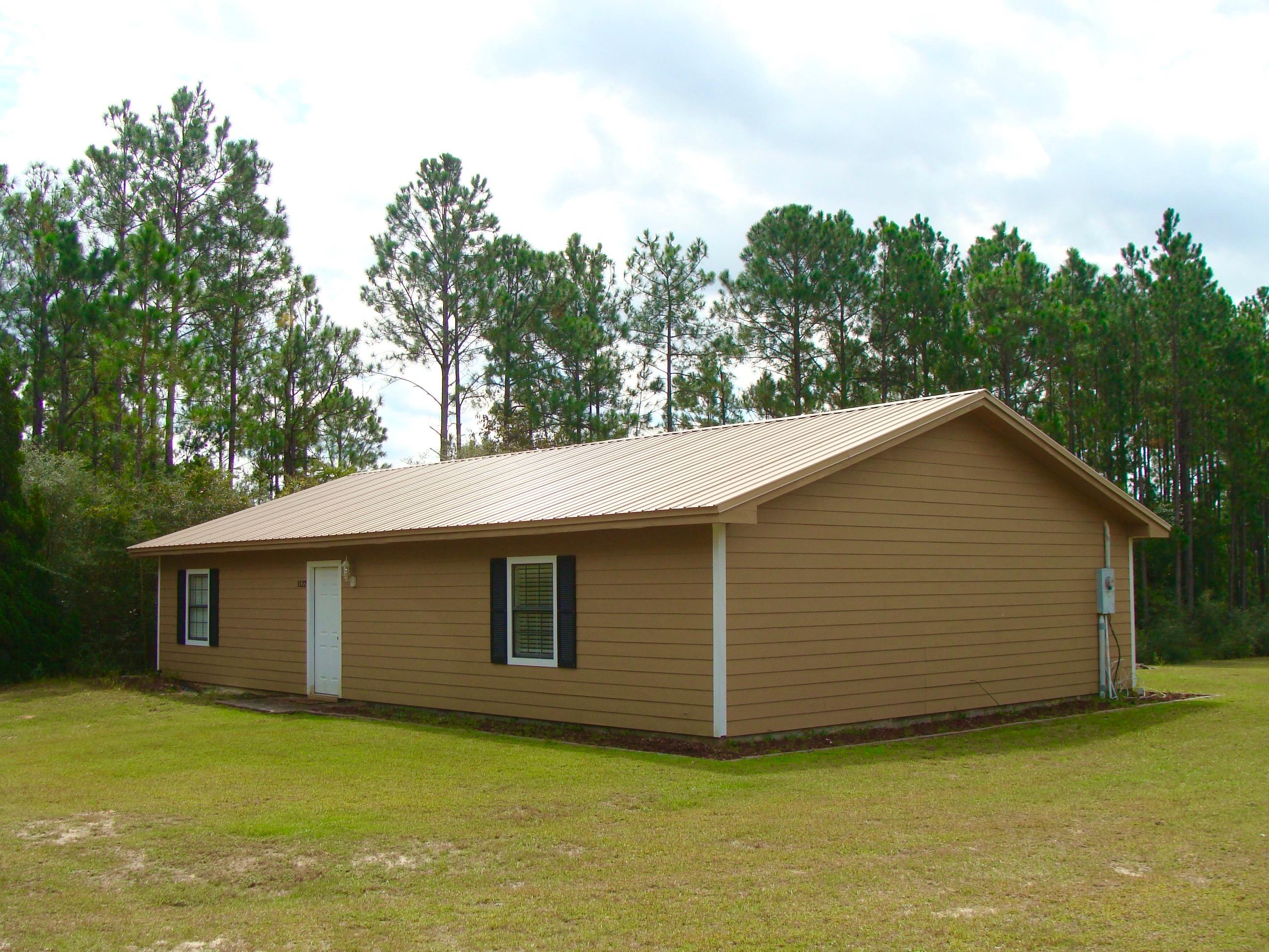 LOW MAINTENANCE HOME ON ALMOST 6 ACRES! This 2BR 2BA home has been recently upgraded with Hardi-Plank type cement board siding and a new metal roof. House is move-in ready with a vaulted living room ceiling, crown molding throughout, hardwood and ceramic tile floors, walk-in closet in Master BR, and a breakfast bar. Perfect for a single person, young couple, or retired couple. Walk through the double French doors to the back yard and you can enjoy almost six (5.86) acres, both cleared & wooded. Private well & septic. There is a 12'x20' storage building in the back yard with insulated walls & ceiling. This property sits midway between DeFuniak Springs and Freeport, so is close to the beaches for both work & play. All measurements and square footage to be verified by buyer at buyer expense