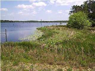 Unique property with waterfront on BOTH King Lake and Lake Holley. Located at the NE end of Bell Drive and south of the King/Holley dam, there is about 3.86 acres with about 191 ft of King Lake waterfront and about 312 ft of Lake Holley waterfront. The property is zoned Rural Village (RV2:1). Easements for access and for maintenance of the dam area is on property (see survey) Public water is available.Property is also accessed thru Holland Drive. HIGHLY MOTIVATED SELLER - BRING ALL OFFERS. Two parcels must be sold together.