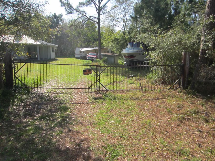 Residential single family lot near the Hogtown Bayou boat launch and Cessna Park. This lot currently has an RV and a boat that will be moved before closing. The lot measures approximately 50 feet wide and 125 feet long. There is a private well on the property now, but public water and sewer is available. 6th Street is unpaved but nice homes have been recently built on the street. There is no homeowners association so no fees to pay. There is no build-out time requirement. Owner will leave the Iron Gate at the entrance. Just a few blocks to great fishing, crabbing, and shrimping.