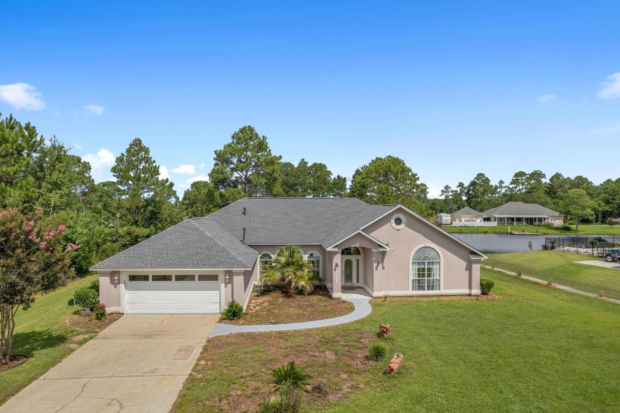 Come see this GORGEOUS lake front home with screened in pool. Open concept kitchen and living room has a beautiful view of the pool and the lake. With a covered patio out the back that has lights and fans you can plan to enjoy the summer with guests by the pool side, and with easy access to I10 they won't have any trouble getting here. Guests getting loud? No problem! With a split floor plan you can have peace and quiet in the master bedroom, while everybody else is on the other side of the house. All bedrooms have its own FULL bathroom so nobody has to share. Also spend some time in the formal living room with a gas fireplace. New roof(2021), new water heater(2021), HVAC is 2004, stove is gas. Home does need some paint, and other small updates but is priced to sell.