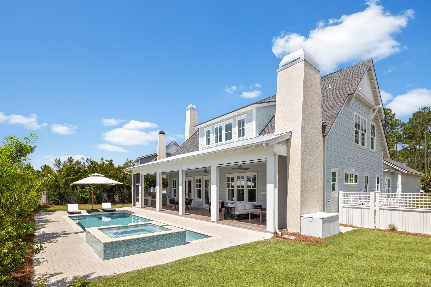 This refined residence in Watersound Origins is a masterclass in outdoor living, set on a private expansive lot that allowed for a custom enhancement of the acclaimed Weatherly floor plan by Romair. With one of the largest private pools in the community, a raised spillover spa, summer kitchen, wood-burning fireplace, and retractable back porch screens, the outdoor experience is both luxurious and versatile. Inside, more than 3,300 square feet of living space has been thoughtfully finished with 10-ft. ceilings, 8-ft. solid core doors, wide oak hardwood floors, shiplap detailing and crown molding throughout. The grand kitchen was expanded exclusively for this lot and offers a 48-in. Thermador gas range beneath a custom hood, dual sinks, quartz countertops, under-cabinet lighting, a Liebherr paneled refrigerator, a KitchenAid ice maker, a beverage cooler, and island with seating for 6. A gas fireplace with an 8-ft. mantel anchors the open living room, while French doors lead to a covered porch with IPE decking, three ceiling fans, a mounted TV, and a fireplace with crushed shell surround. The main-level primary suite offers views of the backyard and pool, dual granite-topped vanities, a large walk-in shower, two spacious walk-in closets and direct porch access. Upstairs, a bonus living area opens to a second covered porch with IPE decking and wood-paneled ceiling. Each of the three guest suites has a private ensuite bath with marble or stone finishes, including walk-in showers with river rock flooring and custom vanities. Additional highlights include a massive 2.5-car garage (26x33) with shelving, a secondary refrigerator and storage, a Generac whole-home generator, tankless water heater, impact-rated windows and doors, and pre-wiring for surround sound and smart home features. The fully fenced backyard is framed by lush landscaping, with magnolia trees, landscape lighting and a brick paver patio. As part of the Watersound Origins community, owners enjoy access to the Village Commons pool and fitness center, tennis and pickleball courts, the Davis Love III-designed golf course, miles of trails, and kayak launch on Lake Powell. Owners have the option to upgrade to full Watersound Club membership for exclusive beach, golf and dining access. All just minutes from 30A, Watersound Town Center and the best of the Emerald Coast.