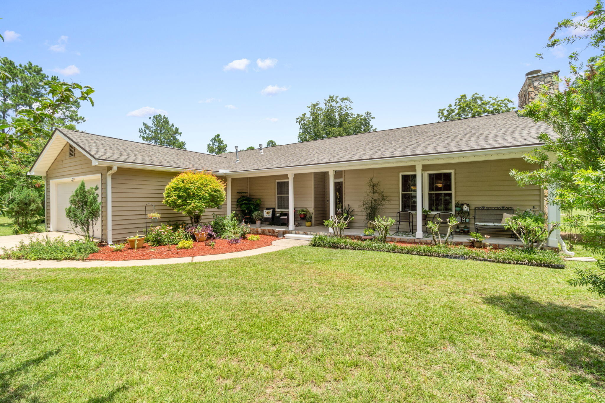 Immerse yourself in the tranquil beauty of this welcoming country home, nestled on 2 acres of meticulously manicured lush lawn. The home offers 3 bedrooms, 2 bathrooms and a spacious living room with tongue and groove cathedral ceiling and stone fireplace. The master suite includes a shower, double vanity and ample walk-in closets. The well-appointed kitchen beckons with a cozy breakfast nook and stainless steel refrigerator and gas stove. Equipped with a 16kw Generac natural gas whole house generator system, you can rest assured knowing you're prepared for any storm. Relax in the hot tub or on the inviting front porch, perfect for unwinding in rocking chairs amidst the serene surroundings. Updates include a new roof and gas water heater in July 2024, freshly painted rooms, and more.
