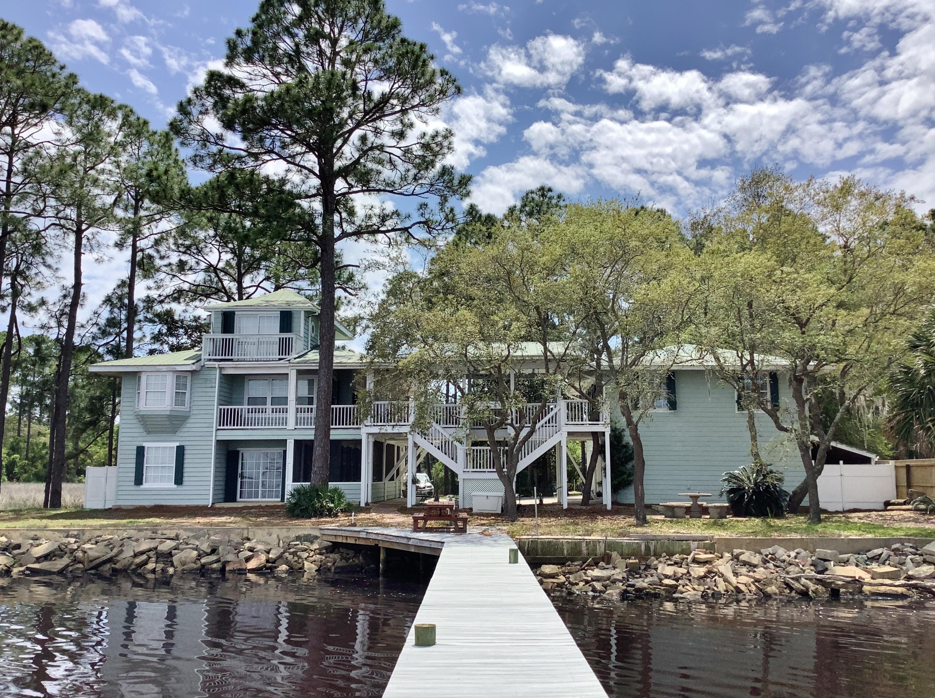 REDUCED! Boaters Paradise situated on a tranquil peninsula with 163ft of prime waterfront, private dock with lift, and intercoastal access. Lovingly known as 'The Bridge House' it's the vision of an award winning, mixed media artist, and her engineer husband with an affinity towards the water. A covered walkway connects main house to guest house, with expansive covered decks capturing breathtaking views of the Bay. Designed for easy Coastal living with a flare towards Southern hospitality, guests and family have their private,1 bedroom, 2 bath Guest House with full Kitchen, Living and Dining Room. Main home is filled with special features and textures like solid Cypress floors, solid Wild Cherrywood Wall and breakfast bar, Solid Oak cabinets, a soaring ceiling surrounded by windows