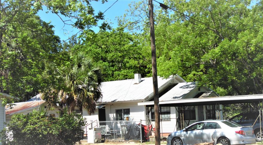 City home near DeFuniak Lake yard, 3 blocks off Hwy 90 on Hwy 83 N. Home is 1582 s.f. with a spacious a large living room and a large dining room off the kitchen. Appliances include a stove and almost new refrigerator. Has space heat. Carpet. was recently installed. Home has one large bathroom with walk-in shower. The front porch is enclosed with lots of windows (FL room), Property partially chain-link. Included is the open carport on the front.