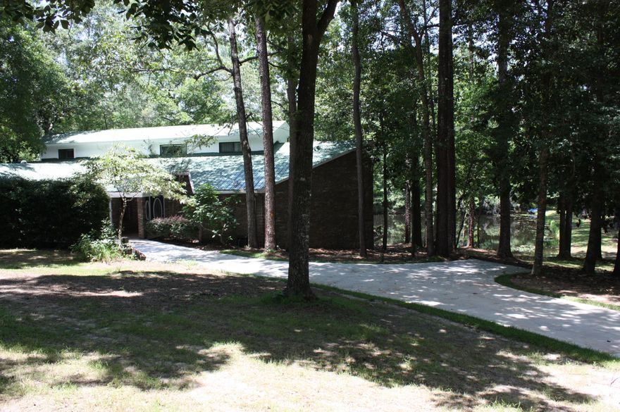 Mountain Dream in Town! Have you ever dreamed of a Mountain retreat in town with a five-minute drive to shopping, Grocery, banks, and schools? This is the Location! There is no mountain just a gentle rolling hill toward the pond but the beautiful large hardwoods and the two flowing streams give it the mountain feel! The pond is full of Bass and Bream so bring the fishing pole! The spring brings a beauty of white dogwood blooms and the fall brings beautiful hardwood yellows , orange and reds! The huge lot is in a subdivision but bring the RV and the vegetative buffer makes you feel like you are deep in the woods! The home is a beautiful two story with the master suite on the first floor. The Pella windows give you the picturesque view of the pond, the dock and the deer in the yard!