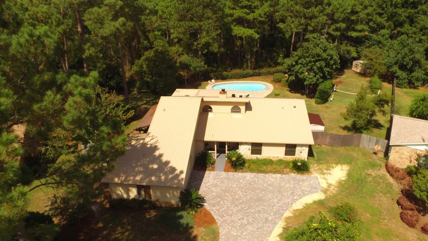 Single story custom builder's home that has been renovated from top to bottom. From the 50 year metal roof (2013) to the large in ground saltwater pool, new paver driveway and granite in 4 rooms, this upgraded home is sure to please. The kitchen features amazing granite countertops, island, dark wood cabinets and newer stainless steel appliances. Extra large crown molding is featured in the dining room and throughout the home. The living room has soaring ceilings along with a stone fireplace. A 16x24 flex/bed room boasts beautiful solid cherry hardwood floors and features a large oak and granite built in entertainment center for your entertaining needs. There is even a large storage room with pocket door attached. A tiled wood look floored bonus room off the master could be a 4th bedroom