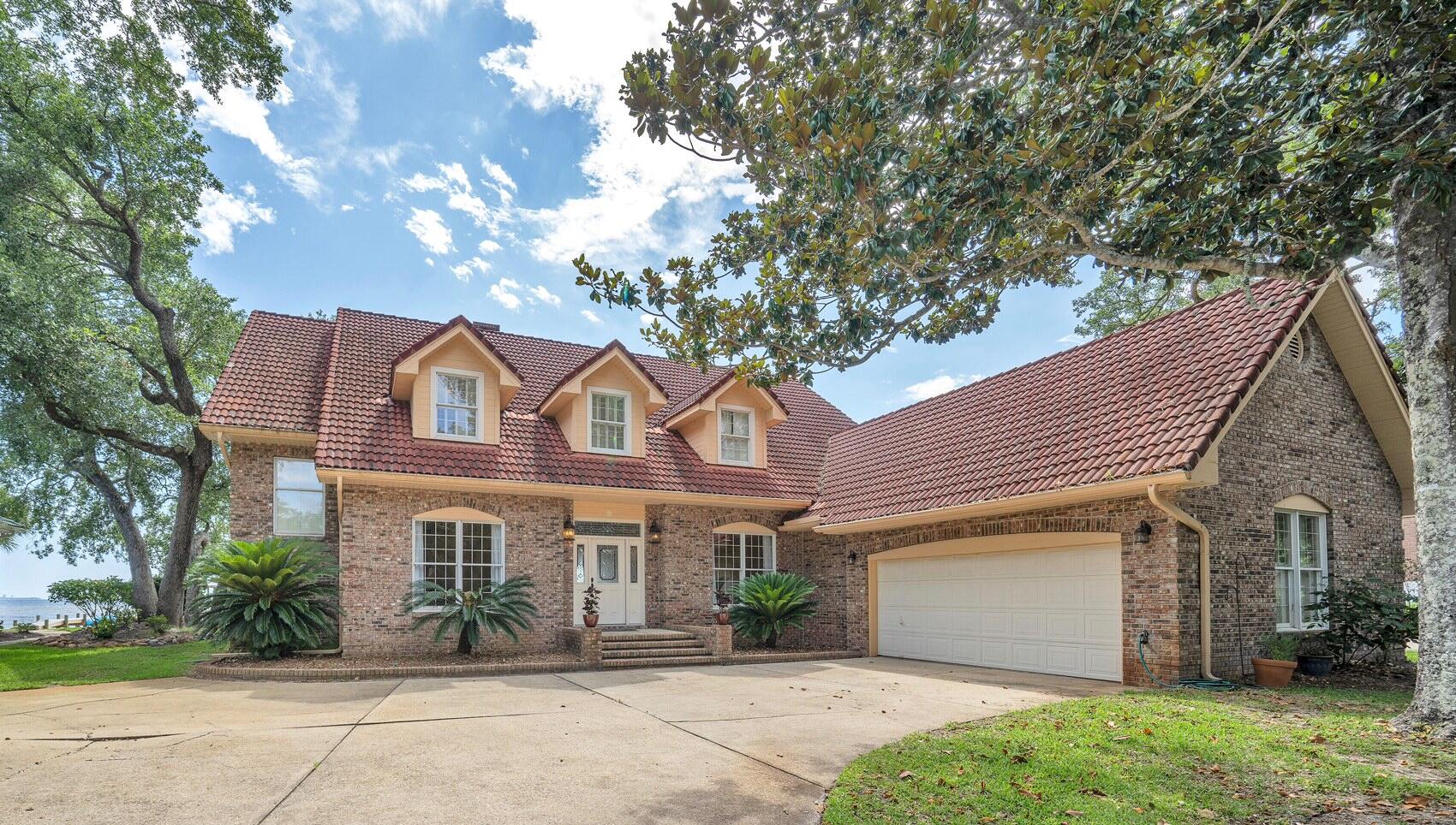Waterfront dreams do come true! Don't miss out on this amazing waterfront home in the gated community of Windward of Bluewater Bay. Enjoy panoramic bay views and gentle bay breezes from the covered back porch or master bedroom balcony! This Barton built home was designed for a family in mind with the master suite and two additional bedrooms upstairs and both formal and informal living and dining areas as well as a guest suite downstairs. Upon entering this fine home, you are drawn to the bay views that greet you through the foyer and Family room. To the left is a large yet cozy living room and to the right is the formal dining room. Both of these rooms have hardwood floors, high ceilings and crown molding. Through a unique arch under the stairs, you enter the bright family room with tile