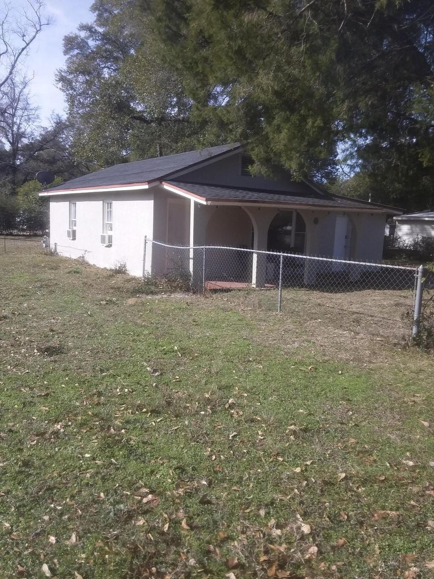 Welcome home to this lovely cottage on a corner lot with a fenced in yard. This cement, block home with metal roof on city water and sewer has room to build if you want to expand. The yard is ample and level. There is a large yard building and a detached garage that can double as a man cave. Right off the main road and no HOA allows for short term rentals. Central to down town, the springs, state parks and white sand beaches this can be an ideal vacation home. Seller is providing a home warranty for peace of mind. Welcome to the Emerald Coast.