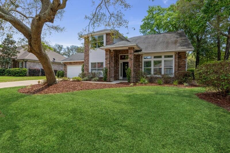 Welcome to the prestigious gated community of Southwind at Bluewater Bay! Located on an executive level street, this spacious 4 bedroom, 3 full bath home includes 2 living spaces, 2 eating spaces, a screened porch, open patio, 2 story outdoor deck and updates galore! Nestled amongst a tree lined street, this home sits on the 3rd fairway of the Bluewater Bay Marsh golf course. Downstairs you'll find soaring vaulted ceilings in the family room and entryway with an updated iron/wood railed staircase. The main living spaces include beautiful wood look tile flooring, updated custom fixtures, neutral paint, and white trim. The first floor boasts a full bedroom (with double entry doors, closet & ensuite bath) that could also be used as an office or flex room. A second door allows for a