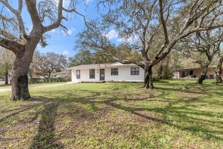 Welcome to your opportunity to own this cute corner lot cottage style home with gorgeous oak trees in the front yard. So many upgrades to enjoy, including a complete re-wire, new roof, new AC, and LVP flooring  installed in 2021.  Bathrooms were remodeled in 2023, to include ceramic tile floors.  GE gas stove/oven, and Whirlpool refrigerator installed in 2022.   Crown molding and kitchen countertop installed in 2024.  Newer screen on porch and gutters installed as well. This home feels much larger with an open floor plan and offers a 2nd living area off the kitchen.
