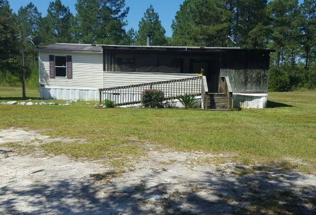 Bring your plans and ideas for this manufactured home on +/- 10 acres in Walton County. Built in 2000, with three bedrooms, two baths, brick fireplace, separate dining area and screened patio. Needs some TLC but many possibilities. This property is bank owned. It is sold in as-is condition without repairs or warranty. Buyer is responsible for verifying all information contained in this listing.