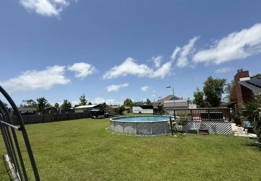Welcome to your dream property! This beautifully maintained 4-bedroom, 2.5-bathroom home is situated on a generous 0.5+ acre corner lot and offers an incredible combination of comfort, functionality, and versatility. With three road access points, you'll enjoy ample parking for RVs, boats, and guests -- including a 50AMP RV charger and a carport for added convenience. Inside, you'll find gorgeous hardwood floors, two spacious living rooms, and a well-appointed kitchen featuring abundant cabinetry and a breakfast bar, perfect for casual meals and entertaining. The home's layout includes plenty of storage and was thoughtfully built on a crawlspace to provide extra durability and access. Step outside to your private oasis -- an oversized backyard with an above ground pool.
