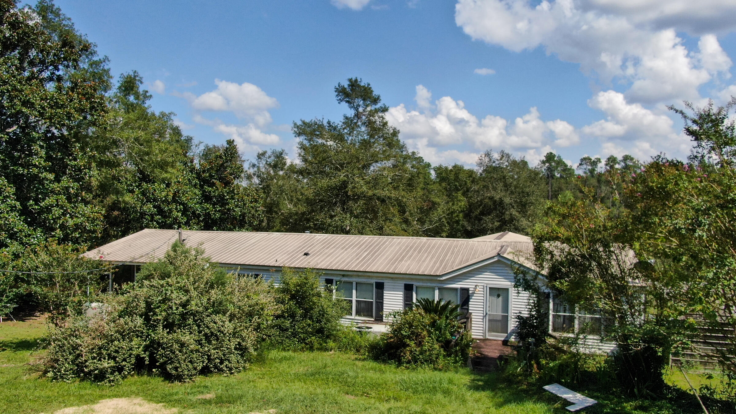 PRICE IMPROVEMENT. 47 acre rural property with Doublewide Mobile Home. Wooded with plenty of wildlife, including deer and turkey. Large spring fed lake for fishing. 3BR, 2BA mobile home, 1568 sq.ft. with 2 large enclosed porches and a covered carport. Property is unrestricted, would be a great weekend getaway for hunting and fishing. Plenty of room for your dream home. 1 hour from the beautiful beaches of Panama City Beach. 2 parcels being sold together, will not separate.Additional parcel # is 00000000-00-0146-0001. Use AS-IS FAR-BAR contract. No survey.