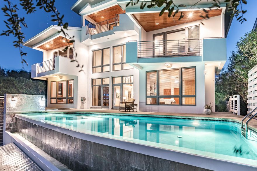 Located across Camp Creek Lake from WaterSound Beach, this secluded waterfront, modern-architecture, fortified-construction home with infinity pool is one of only 16 properties in the private subdivision of Camp Creek Point. With almost 5000 sq ft, the home design takes advantage of the views and light corridors. Watch the stars at night from inside the living room with the expansive ceiling. Bonus living area on the 3rd floor offers a secondary indoor retreat, or could easily be converted into an additional ensuite bedroom with incredible views with balcony. Elevator, solid Hickory flooring, custom Maple cabinets, Spanish Cedar entry, garage, home generator, and much more! Walk to the beach on the neighborhood boardwalk or paddle your kayak or paddle board from your private boat dock.