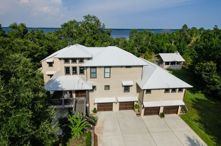 EXCEPTIONAL WATERFRONT LIVING AT IT'S BEST! SUPER PRIVATE YET ONLY A SHORT DISTANCE TO PENSACOLA!DEEP WATER WITH 3.5 ACRES SHADED WITH MAJESTIC OAKS . SPECTACULAR VIEWS!If you are looking for a custom built waterfront home on acreage, this is it! This 5,053 sf three level residence with 5 bedrooms and 4-1/2 baths with 5 oversized garages has designer finishes and luxurious amenities throughout.The front entry into the home is showcased by a 2 story foyer with multiple Kolbe & Kolbe windows allowing for natural light, and a craftsman built staircase leading to the upper level.The main level offers water views from the living room, dining area, and a separate hearth room with fireplace, also serviced by an elevator.Entertain with the amazing chef's kitchen