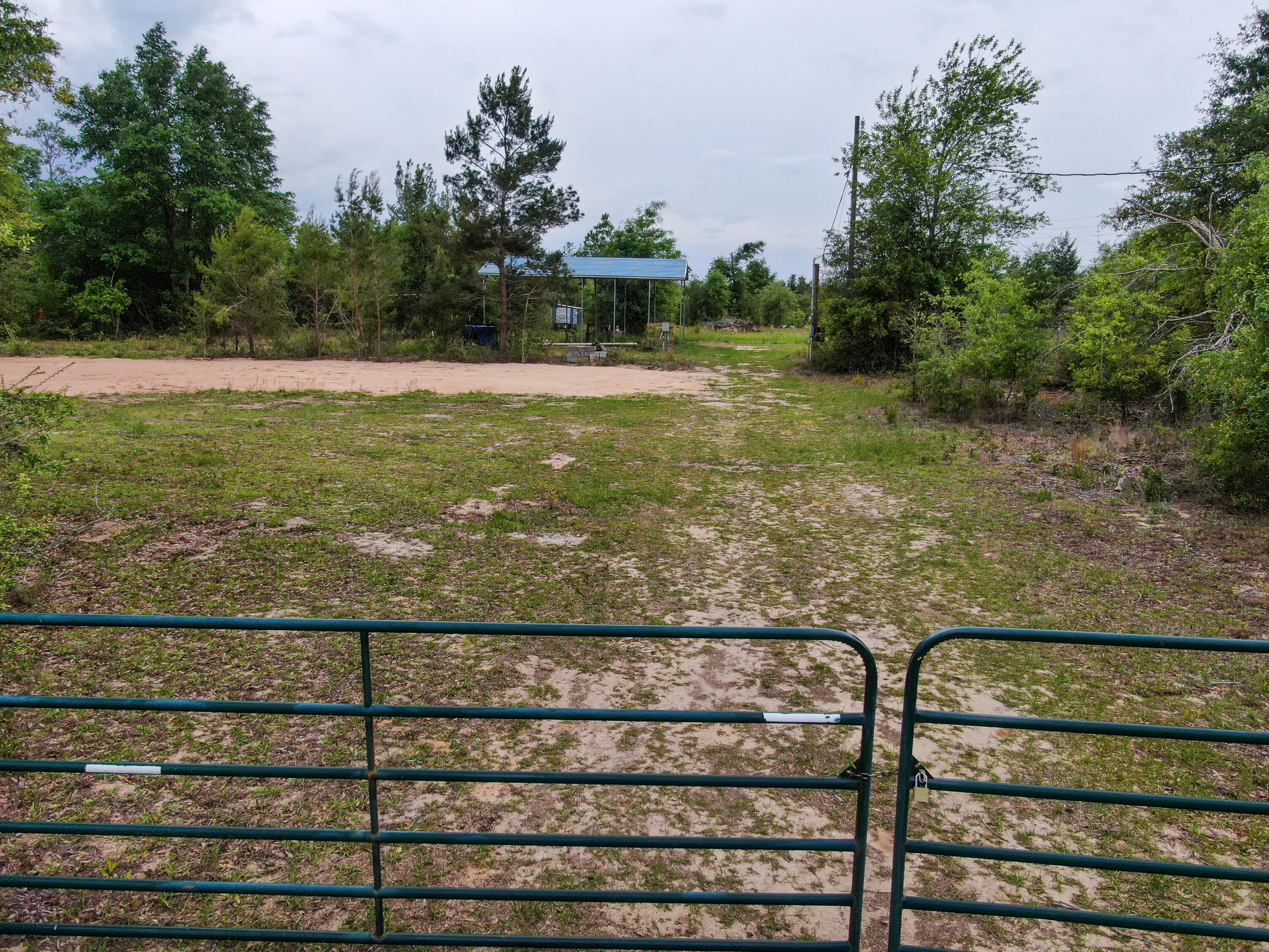 Private 2.5 Acres of land, which comes with a well and septic. A mobile home was previously on the property. Chicken coop and 8x30 11ft tall metal framed camper cover on the property that conveys.