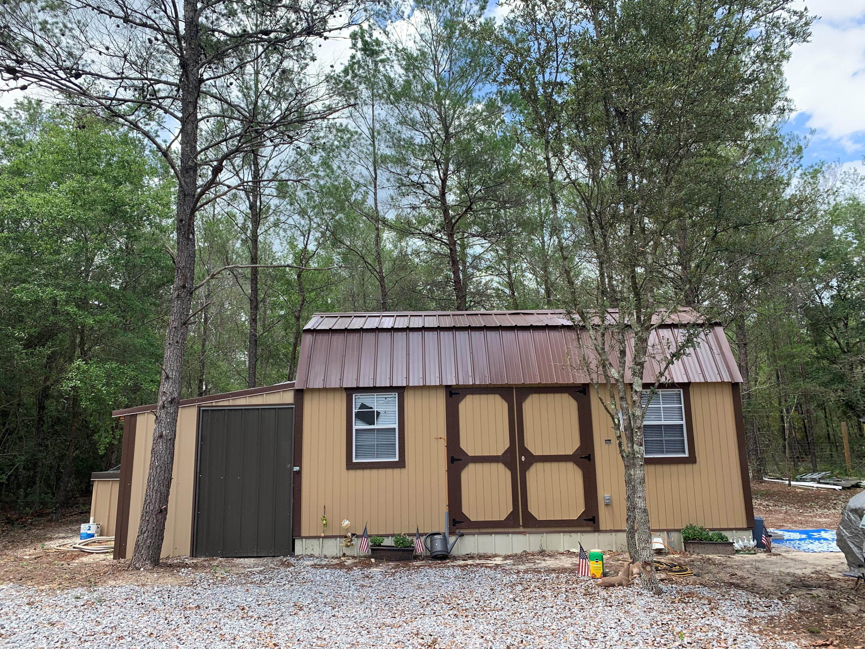 If you're looking for a private getaway, look no more. This almost half acre lot is completely fenced in with a hedge of wooded privacy all around. There is a bunk house already in place with an attached enclosed lean to & two RV hookups (1 is currently hooked up to bunk house). There is a 55 foot well (with warranty), RV septic, & power. 2 - 10 x 12 sheds with power are on the property. This property is conveniently located between Defuniak Springs & Crestview & 1 hour from the white sandy beaches of the Gulf of Mexico. Give us a call to schedule your showing!!