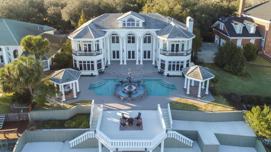 This extraordinary waterfront estate sits over twenty feet high on a bluff overlooking Choctawhatchee Bay. Enjoy panoramic views of Okaloosa Island to the south, Destin to the east, and Niceville to the north. Aged oak and cypress trees line the driveway to the majestic porte-cochere, and a large koi pond with a waterfall captures the serenity of the setting. Oversized arched double doors welcome you to the heart of the home--the main living space that has soaring 30-foot ceilings, a winding staircase to the second floor, and double-sided fireplace encased in a handcrafted wood mantel. This residence's appointments are exceptional: hardwood floors, deep crown molding, faux painting, custom cabinetry, arched doorways, five fireplaces, surround sound, palladium windows, exquisite lighting