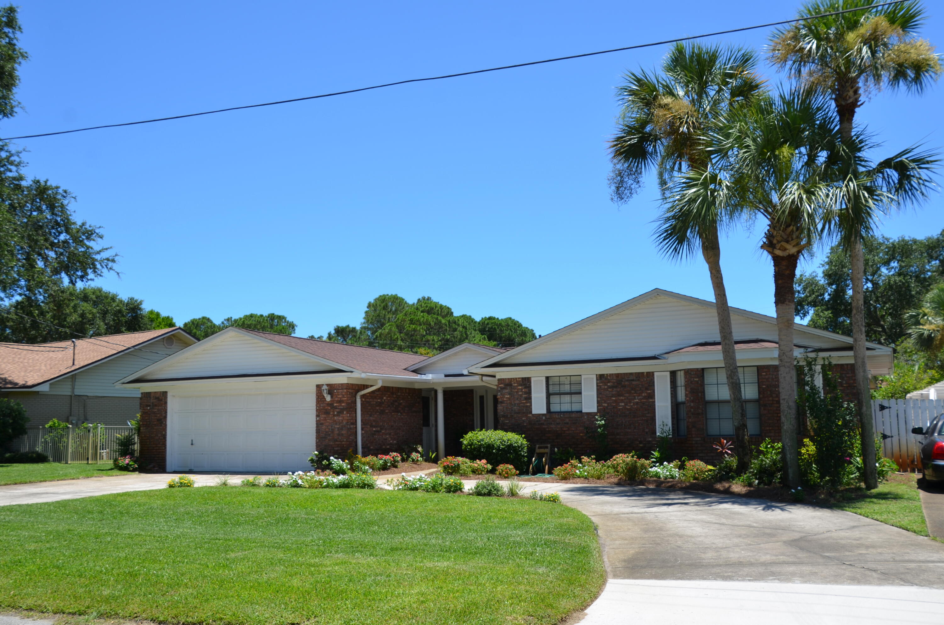 Large home priced to sell! 100% financing for first-time homebuyers is available for this home. Please see attached flyers in Documents. Priced well below comps for square footage, this Heart of Destin home features an attached apartment that has its own entry, full kitchen, full bathroom, bedroom, extra room, and driveway. No HOA in this neighborhood. Adequate space for boat or RV parking. Three separate living areas let everyone do their own thing without interruption. The irrigation for the landscaping is provided by a shallow well with a new pump motor (2023) and underground sprinkler system. The inground gunite swimming pool has a new pump motor (2023), diving board, 8-1/2' deep diving well, and slide. The privacy-fenced backyard boasts a raised sundeck with a sprinkler for the kids