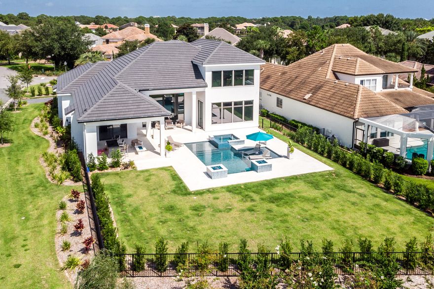 One word fits this home: Impressive! This gorgeous new home boasts dramatic spaces, sleek finishes, quality construction and smart technology--all on a fabulous golf course lot with stunning sunset views!Designed with modern, busy lifestyles in mind, this home works hard so you don't have to! Easy to clean surfaces, abundant storage options, and phone-activated controls are just a few of the conveniences it offers in abundance. The grand foyer opens to the amazing great room, which boasts a 16' high trey ceiling, polished white terrazzo floors, rich mahogany trim, custom lighting options for the ceiling/baseboards and a water vapor 'fireplace.'