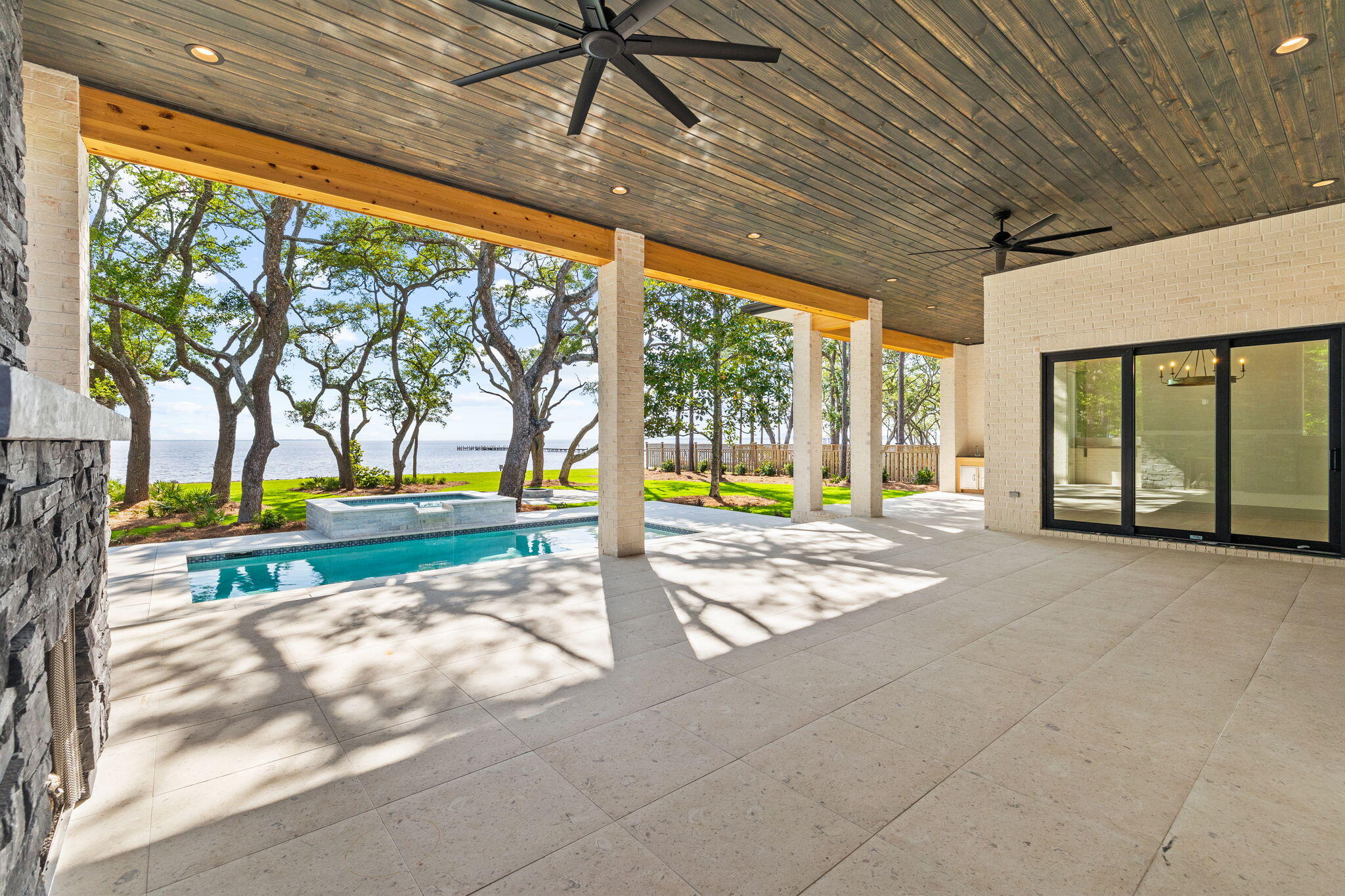 This custom Bayfront home in Steamboat Landing at Hammock Bay is presented by Simmons Custom Home Builders. They are proud to share this 2,964 sq ft home on the Choctawhatchee Bay with stunning views for days. The 1/2 acre lot includes a new seawall with riprap in place on the oversized lot with 117' of water frontage, 3 car garage, private pool & hot tub and meandering rock pathways under the 100-year Oak trees to your own private dock. Living easy in this sprawling 4 Bedroom, 3.5 Bath ranch with Primary waterfront suite with double closets, freestanding tub, double shower head shower with private entrance to the covered waterfront porch. On the opposite side of the home, you will find another waterfront guest room, 2 additional bedrooms, two full baths, a half bath and a large laundry