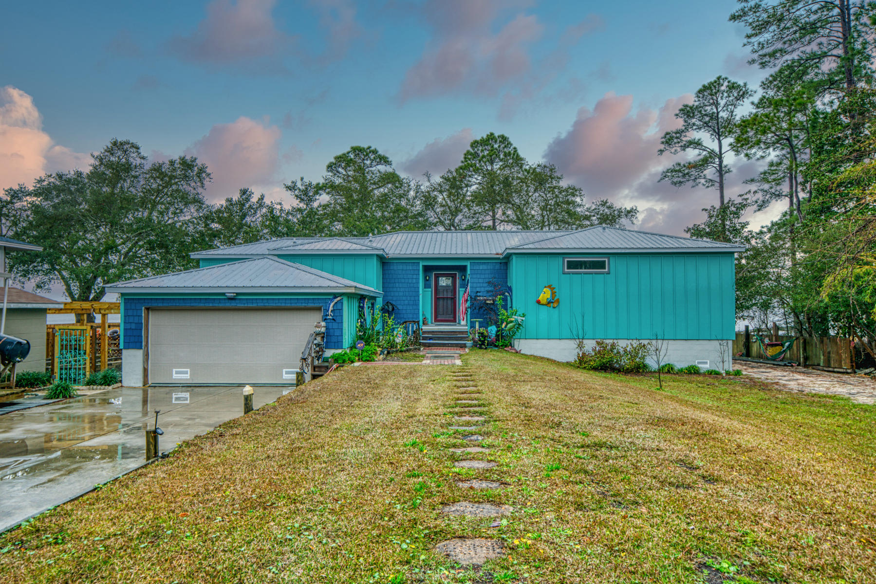 Beautiful custom built BAY FRONT home with metal roof, double car garage, hardie siding, low E windows. Built in 2016 to latest/new codes offering a workshop, green house, trellis over raised garden, fruit orchard, fabulous bay views with over 600 sq ft of outside trek decks, dock, covered boat lift, incredible sunsets. Spilt gas/electric hvac called hybrid, gas tankless water heater. This custom built home offers 9 ft ceilings, Brazilian Cherry hardwood floors thru out home with upgraded carpet in master bedroom and guest bedroom. Walk in master closet, dual sinks with walk in marble shower. The open kitchen features antique white glazed cabinets, glass uppers, gas stove, cabinet pantry plus additional sliding glass door pantry. Large lot with covered RV parking with attached work shop